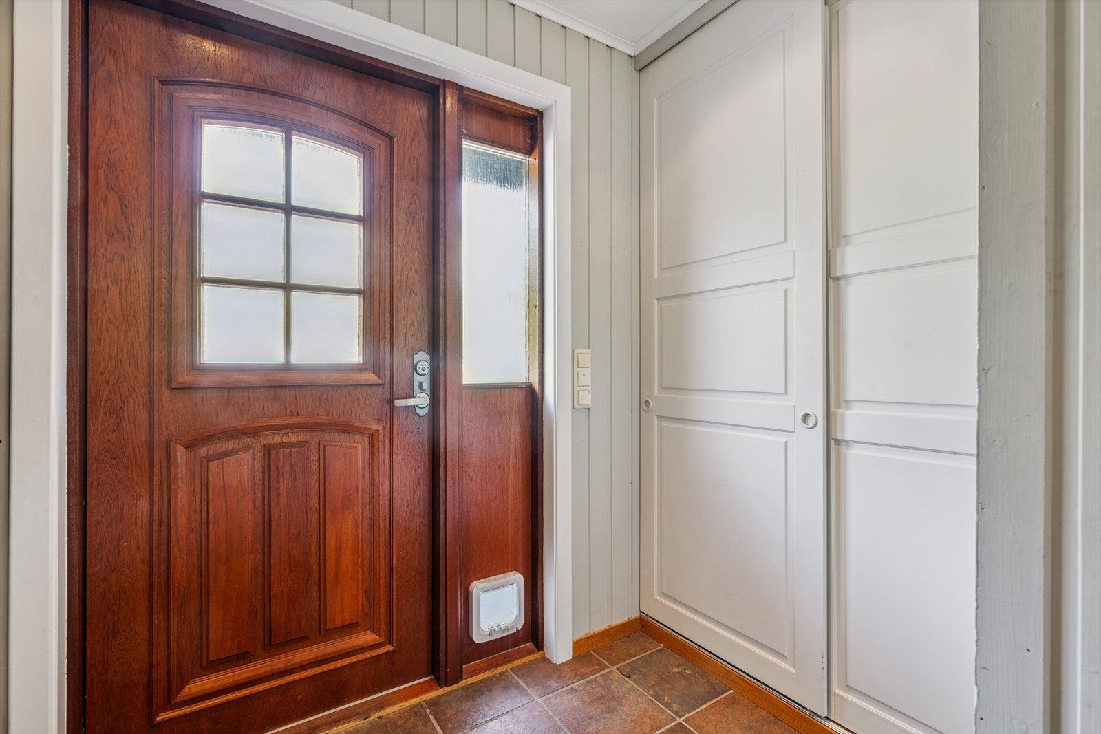 Vindfang med garderobeløsning og varmekabler i gulv. Her er det god plass til å henge av seg yttertøy. Galleribilde