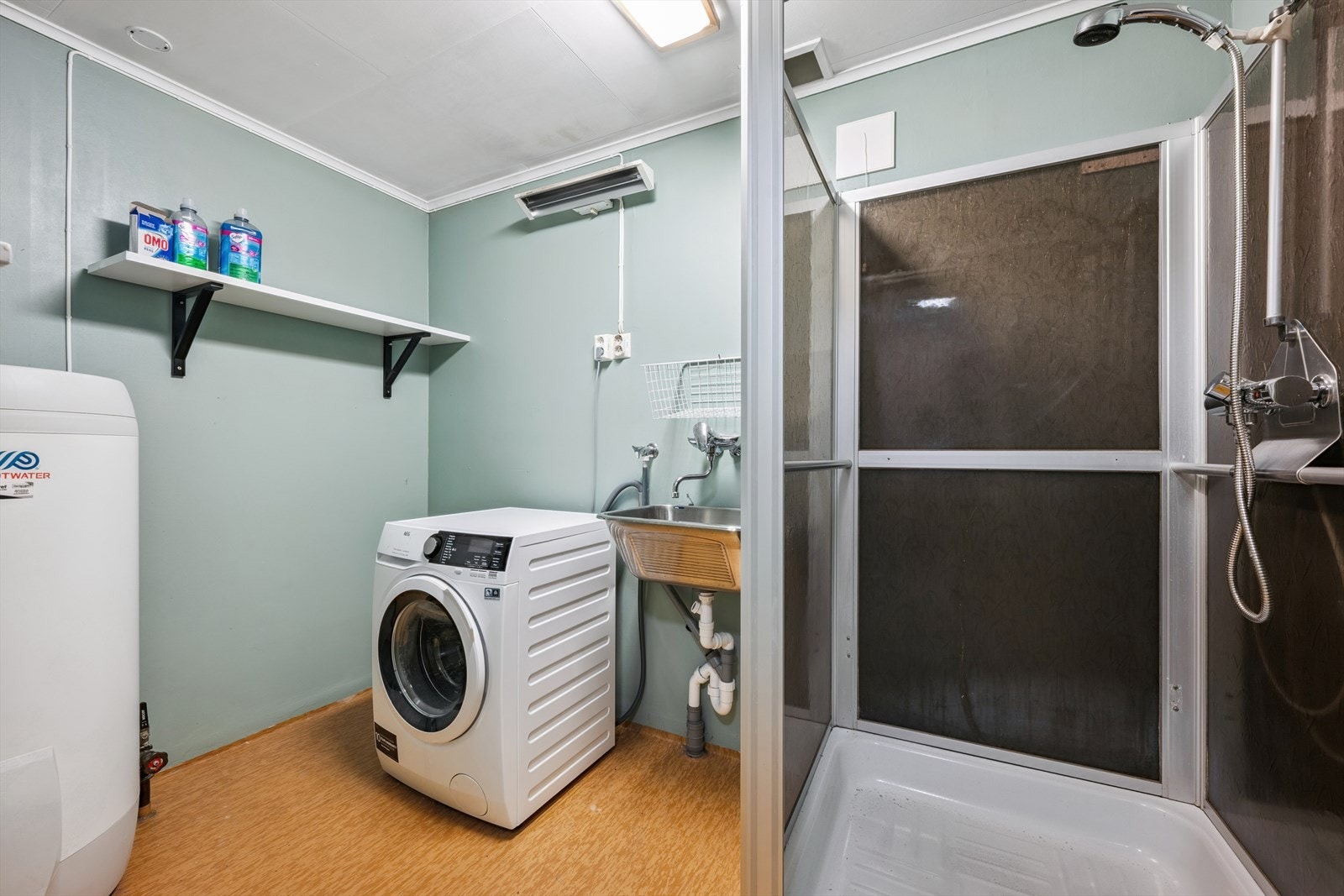 Vaskerom med dusjkabinett, utslagsvask og opplegg for vaskemaskin Galleribilde