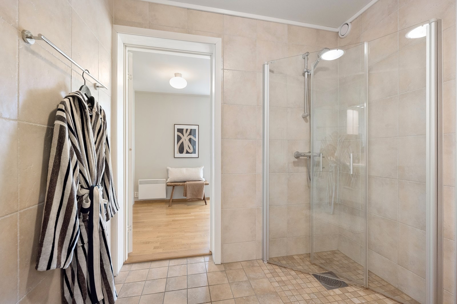 Videre finner du vegghengt klosett med innebygd sisterne, dusjsone med innfelte dusjdører i herdet glass samt opplegg for vaskemaskin. Galleribilde