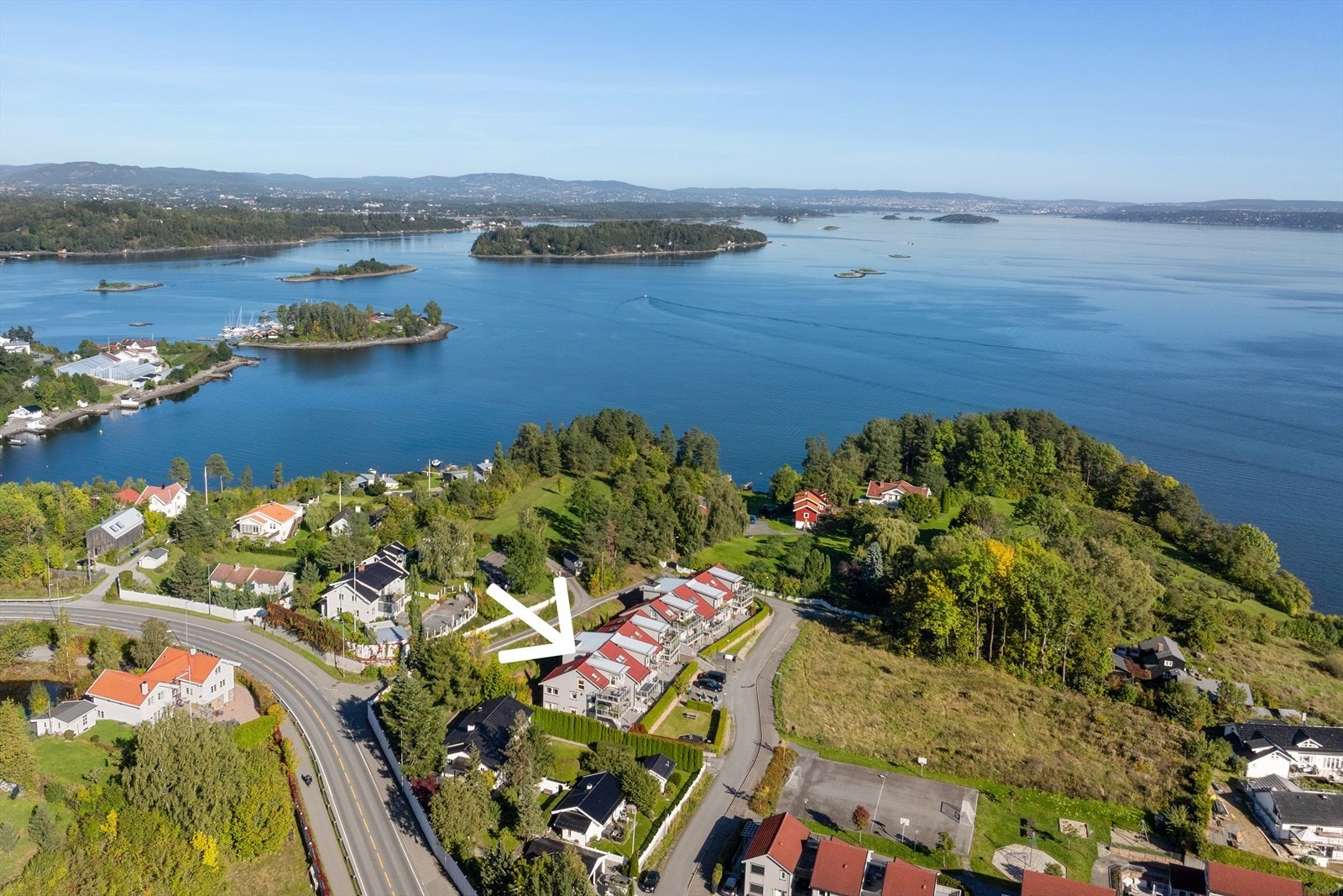 Til høyre i bildet ser du den andre lekeplassen med fotballbane. Denne er organisert som et realsameie der beboerne i området eier hver sin andel. Galleribilde