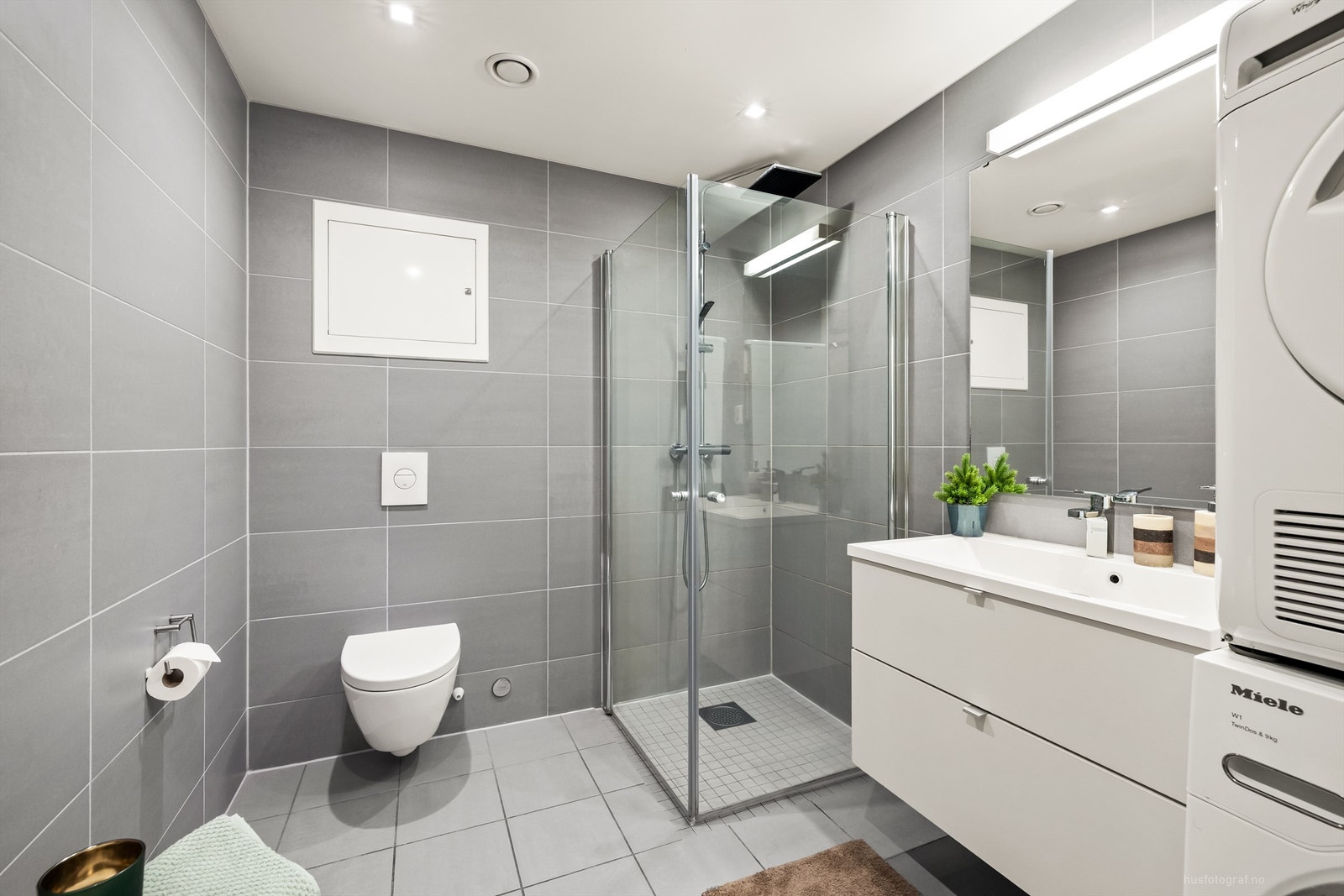 Lyst og pent bad med dusjhjørne som har regnfallsdusj Galleribilde