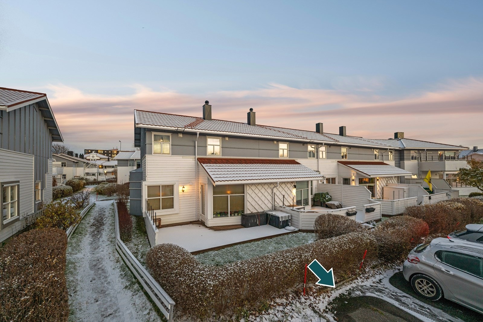 Det følger egen parkeringplass rett utenfor rekkehuset, som anvist med pil. Galleribilde