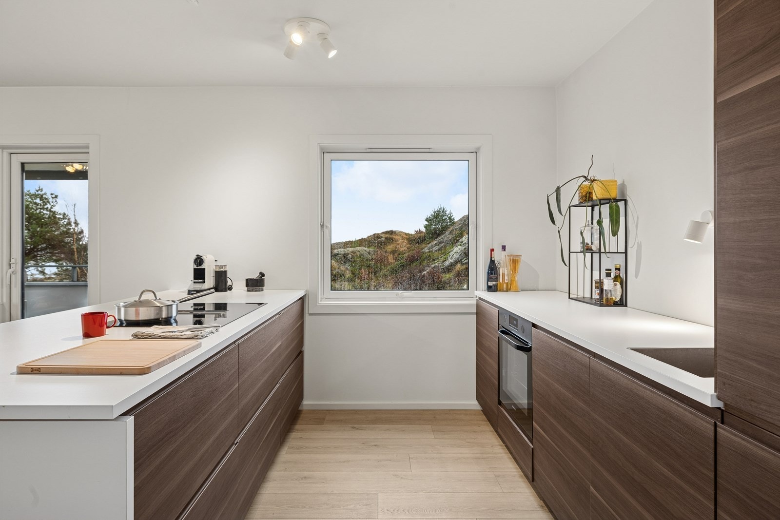 Integrerte hvitevarer som platetopp med nedfelt vifte, stekeovn, oppvaskmaskin og kjøleskap med frys. Galleribilde