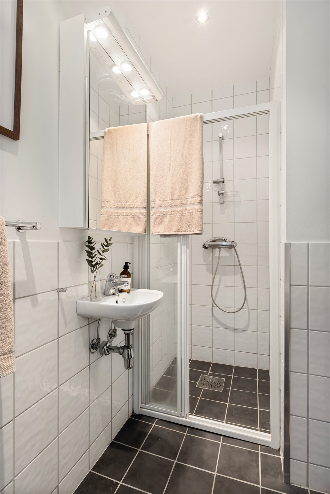 Badet er utstyrt med dusjnisje med glassdører på skinne, mekanisk avtrekk, rørfordelingsskap, bereder og gulvstående wc. Galleribilde