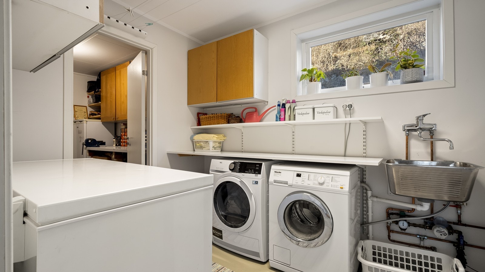 Praktisk vaskerom med adkomst til bod og direkte til den ene garasjen Galleribilde