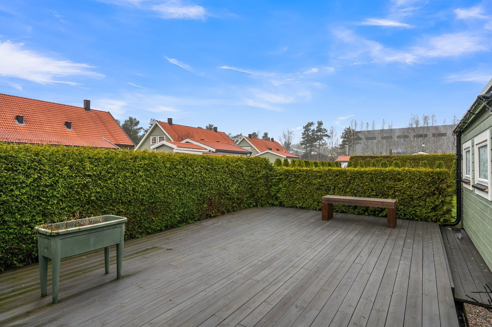 En usjenert platting, oppført i 2025, gir en ekstra, privat uteplass, pent innrammet av hekkbeplantning. Galleribilde