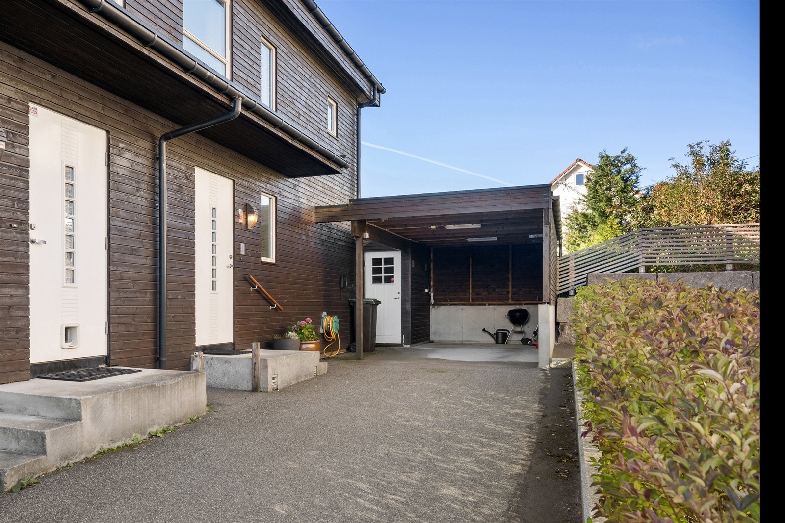 Boligen har egen carport med elbillader, praktisk plassert ved inngangspartiet Galleribilde
