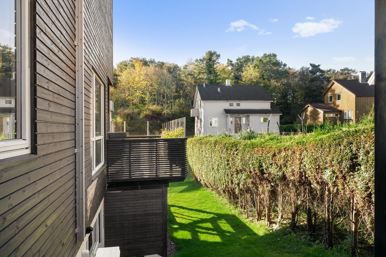 Bildet er tatt fra uteboden mot balkongen. Her ser man deler av gressplenen, som fortsetter på fremsiden av tomten Galleribilde