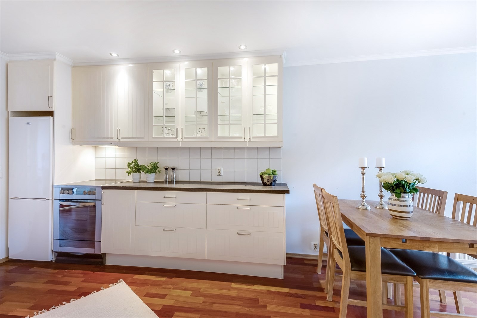 Flere fronter har glass felter med belysning og vegg over benkeplaten er flissatt. Galleribilde