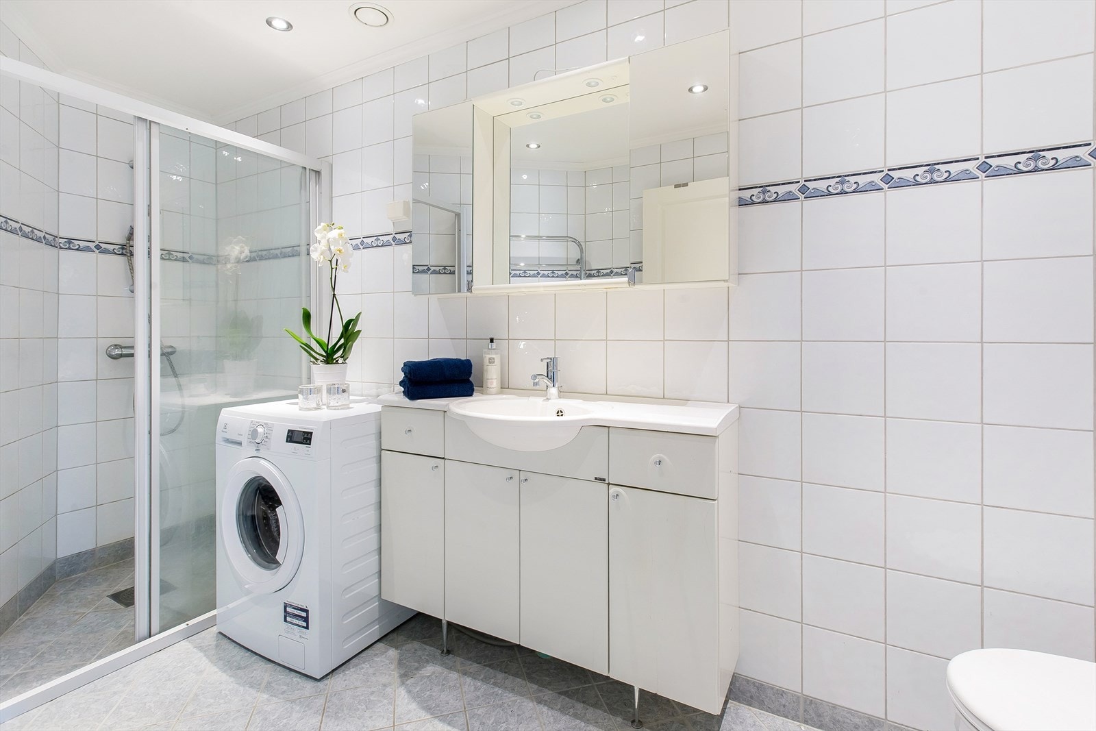 Pent flislagt bad med varmekabler i gulv og downlights i tak. Galleribilde