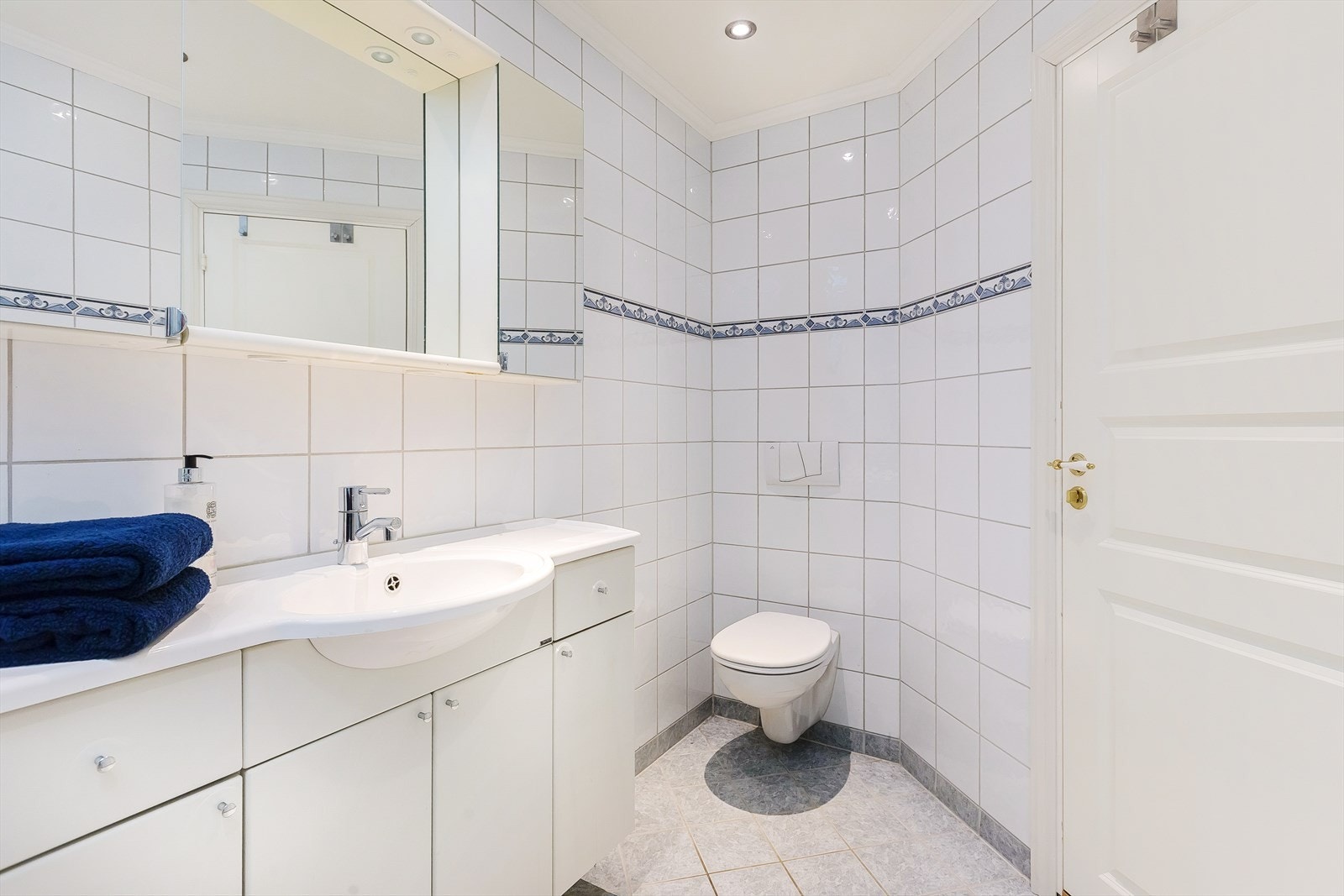 Videre er badet utstyrt med vegghengt toalett, dusjhjørne og opplegg for vaskemaskin. Galleribilde