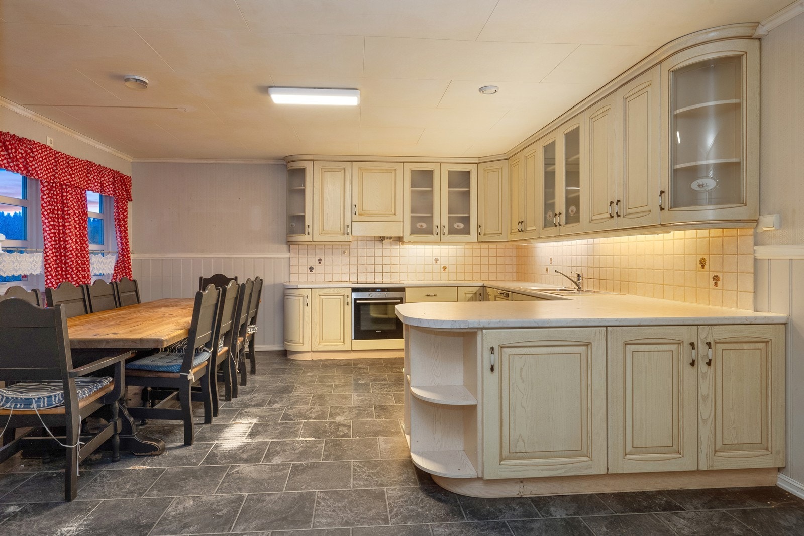 Stort kjøkken med åpen løsning og plass til stor spisegruppe. Galleribilde