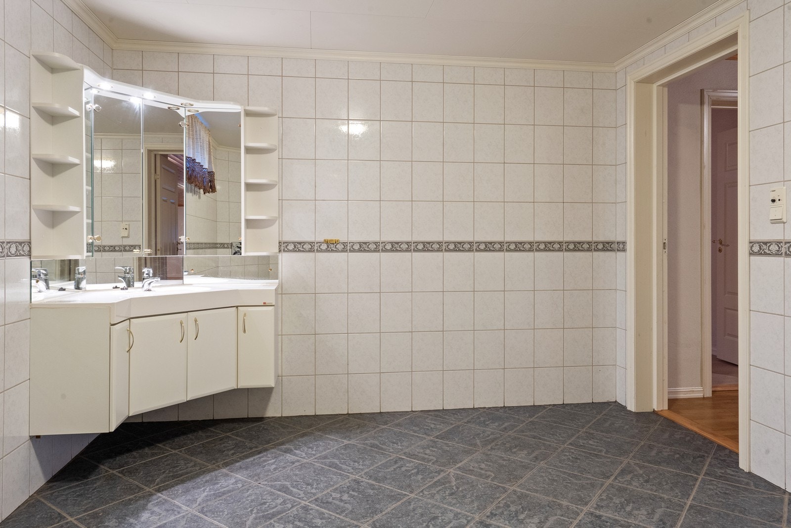 Flislagt bad i underetasjen med servantinnredning og boblebadekar. Galleribilde