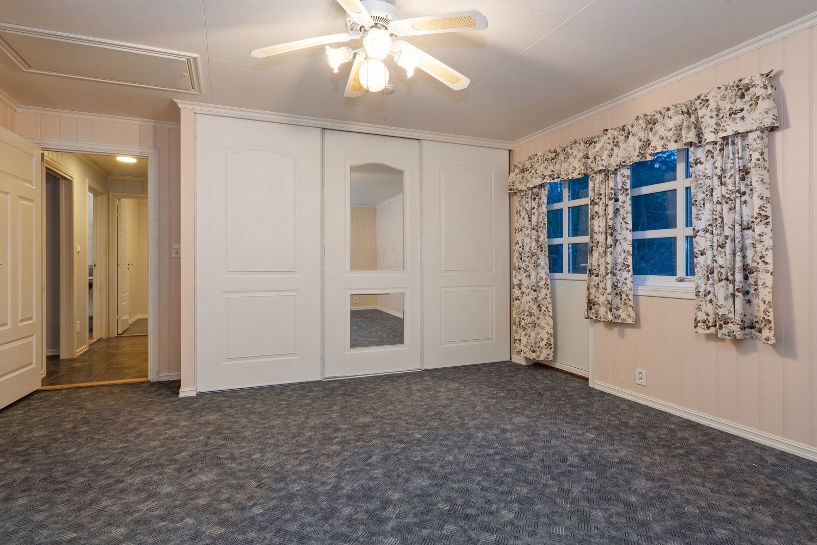 Det er to soverom i 1. etasje. Her er hovedsoverommet med garderobeskap og verandadør. Galleribilde