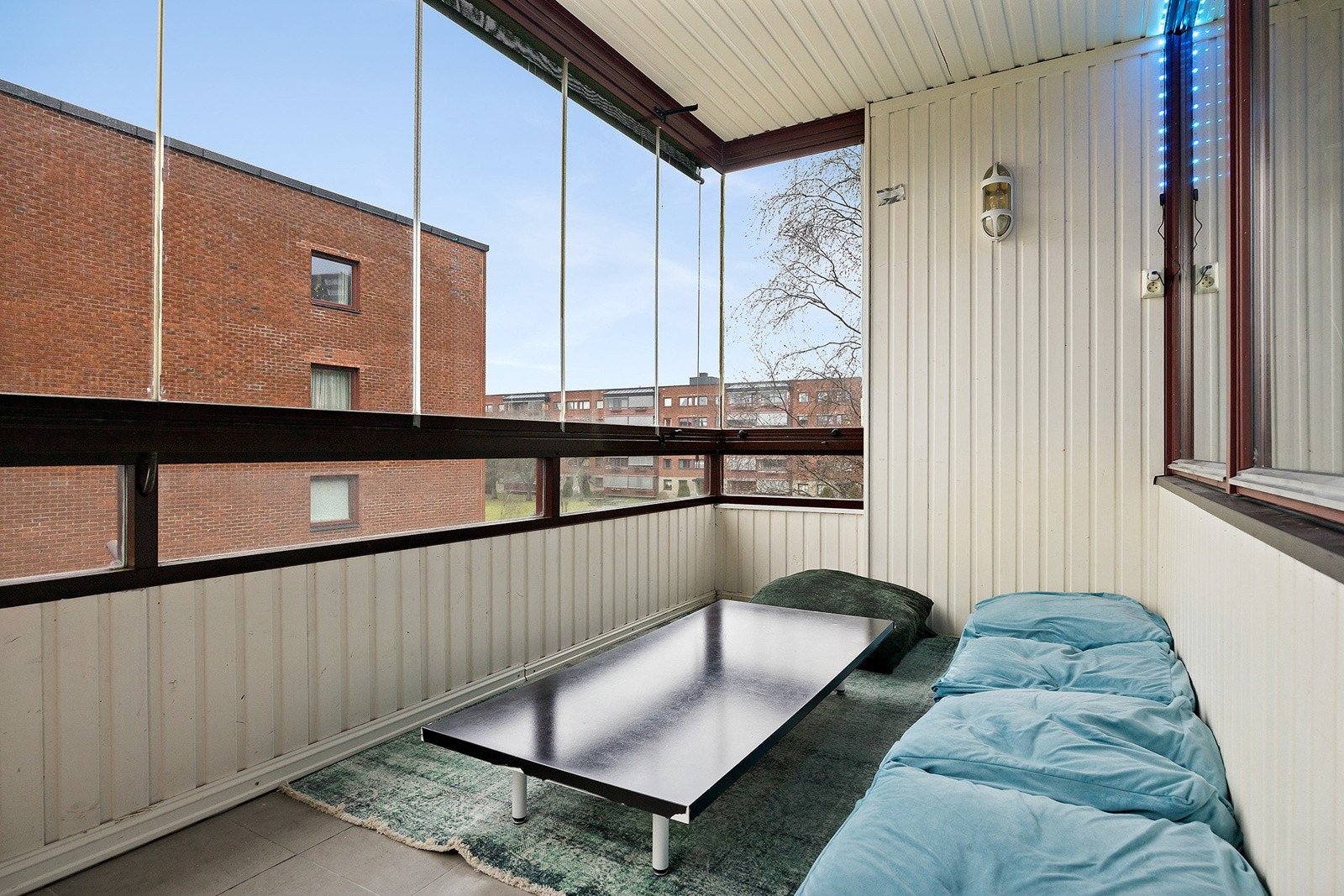 Balkongen har flislagt gulv, belysning og strømuttak Galleribilde