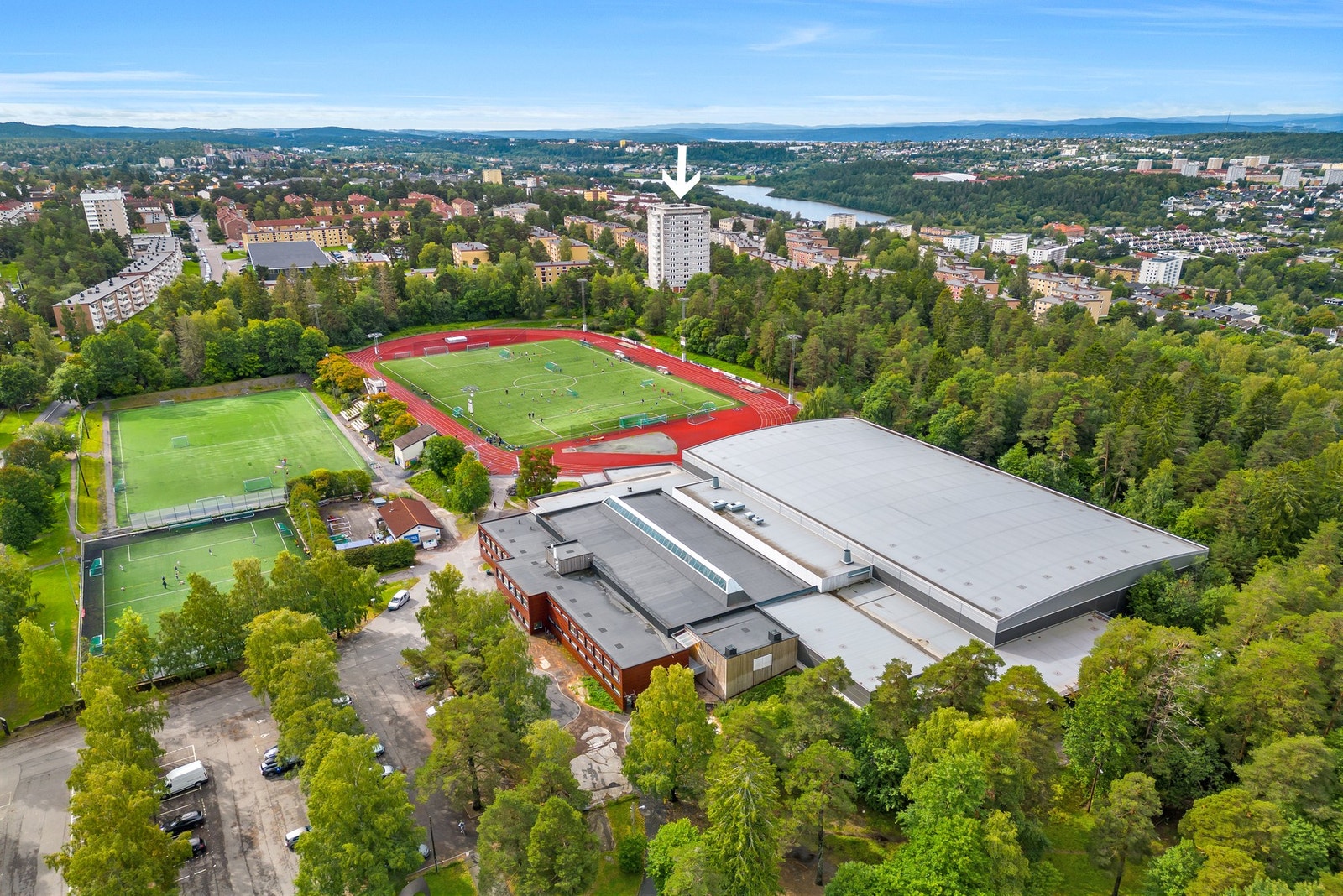 Leiligheten ligger fint plassert i rolige omgivelser med sentral beliggenhet. Fra boligen er det kort vei til friidrettsbane. Leilighet markert med pil. Galleribilde