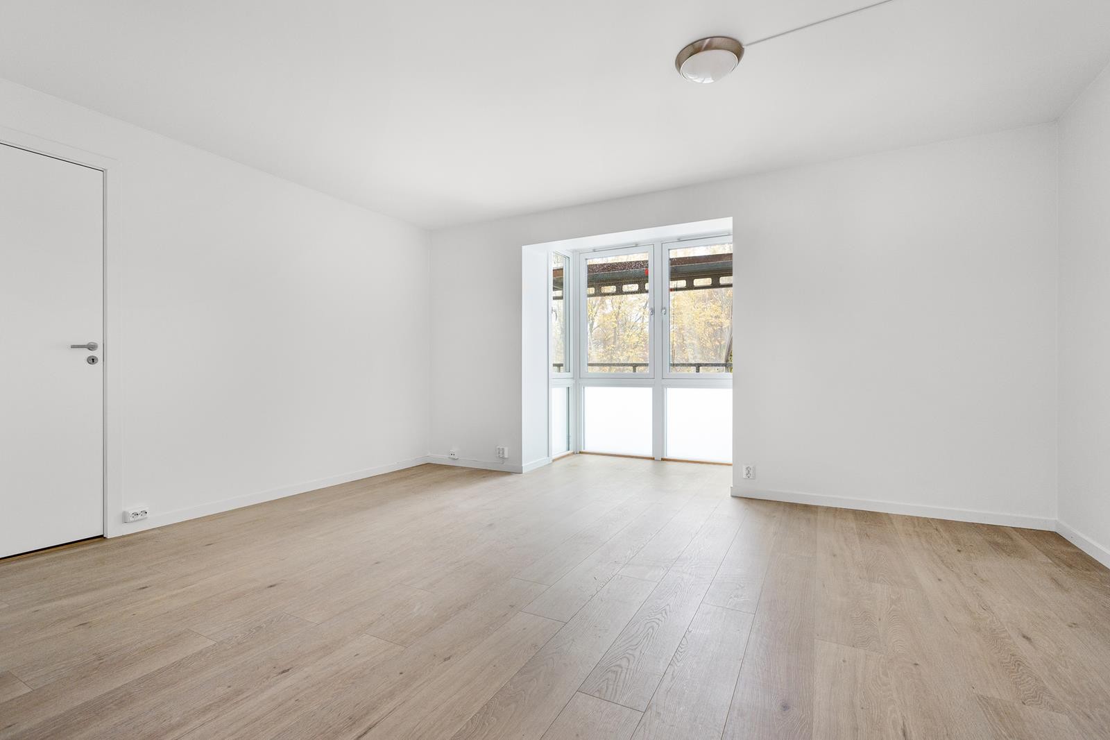 Romslig stue med mye lys og koselig karnapp Galleribilde