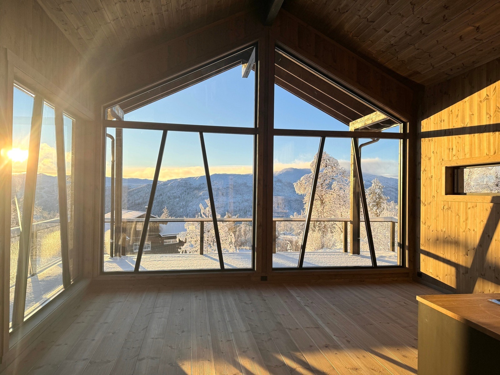 En lys og moderne nybygd hytte, med store panoramavinduer som slipper naturen helt inn Galleribilde