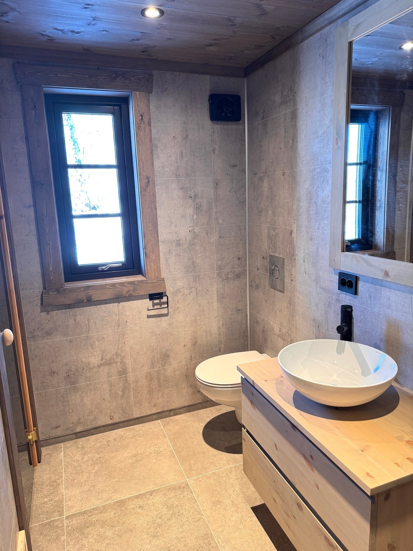 Flott bad med flislagt gulv med varmekabler, våtromsplater på vegger og panel i himling Galleribilde