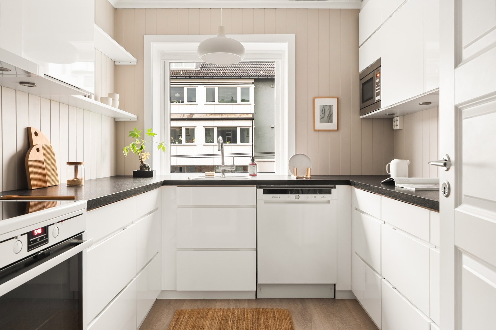 Flott kjøkken med slette fronter og laminat benkeplate. Galleribilde