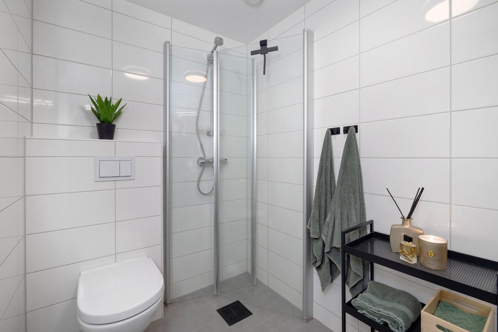 Badet er utstyrt med servantskap, speil med lys, vegghengt toalett og dusjhjørne med svingbare glassdører. Galleribilde