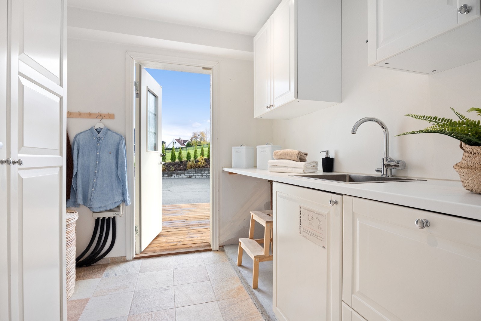 Praktisk og romslig vaskerom innenfor kjøkkenet med utgang til terreng mot gårdsplassen Galleribilde