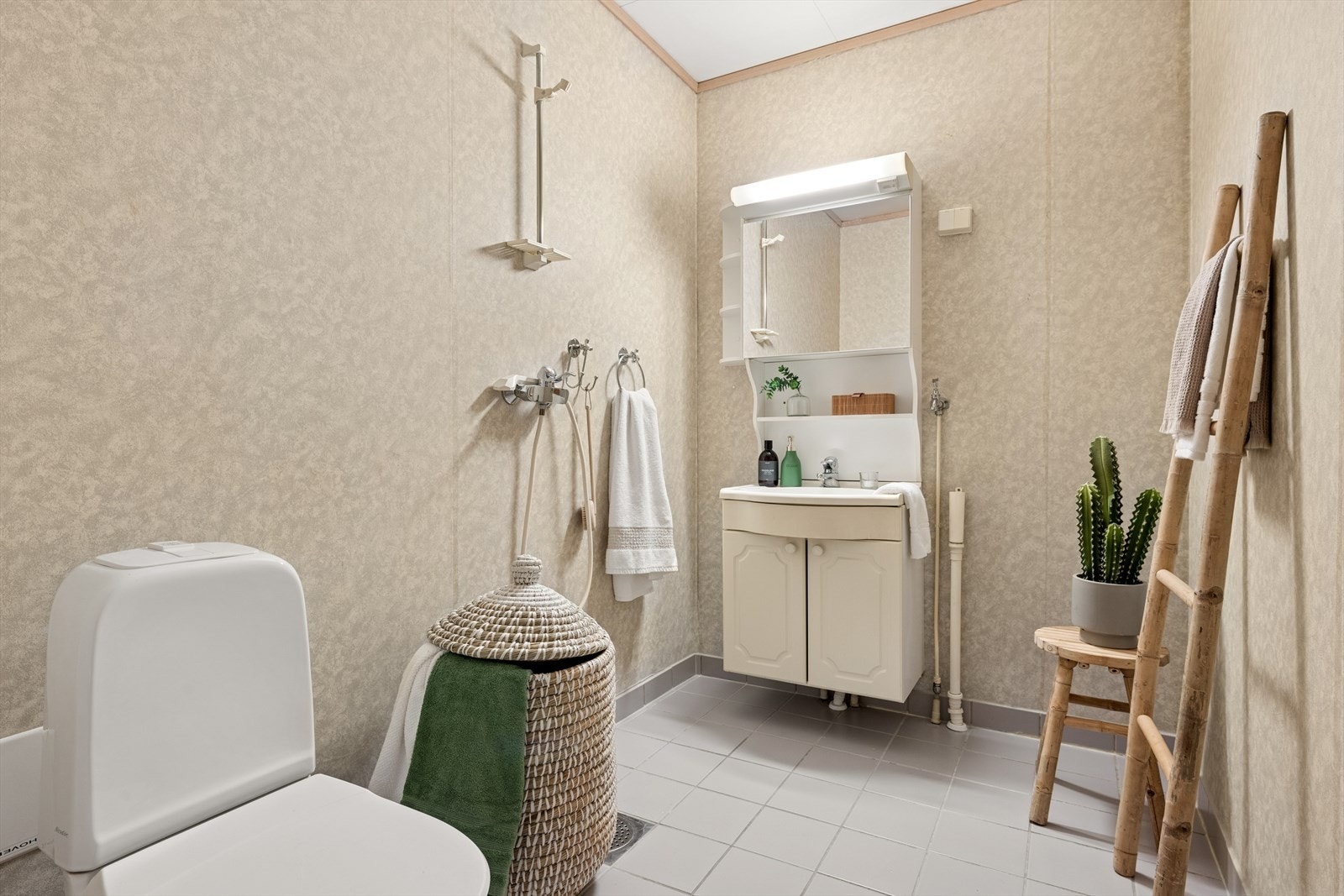 Baderommet i første etasje er utstyrt med gulvstående toalett, dusj direkte på gulvet samt servant med skapinnredning under. Galleribilde