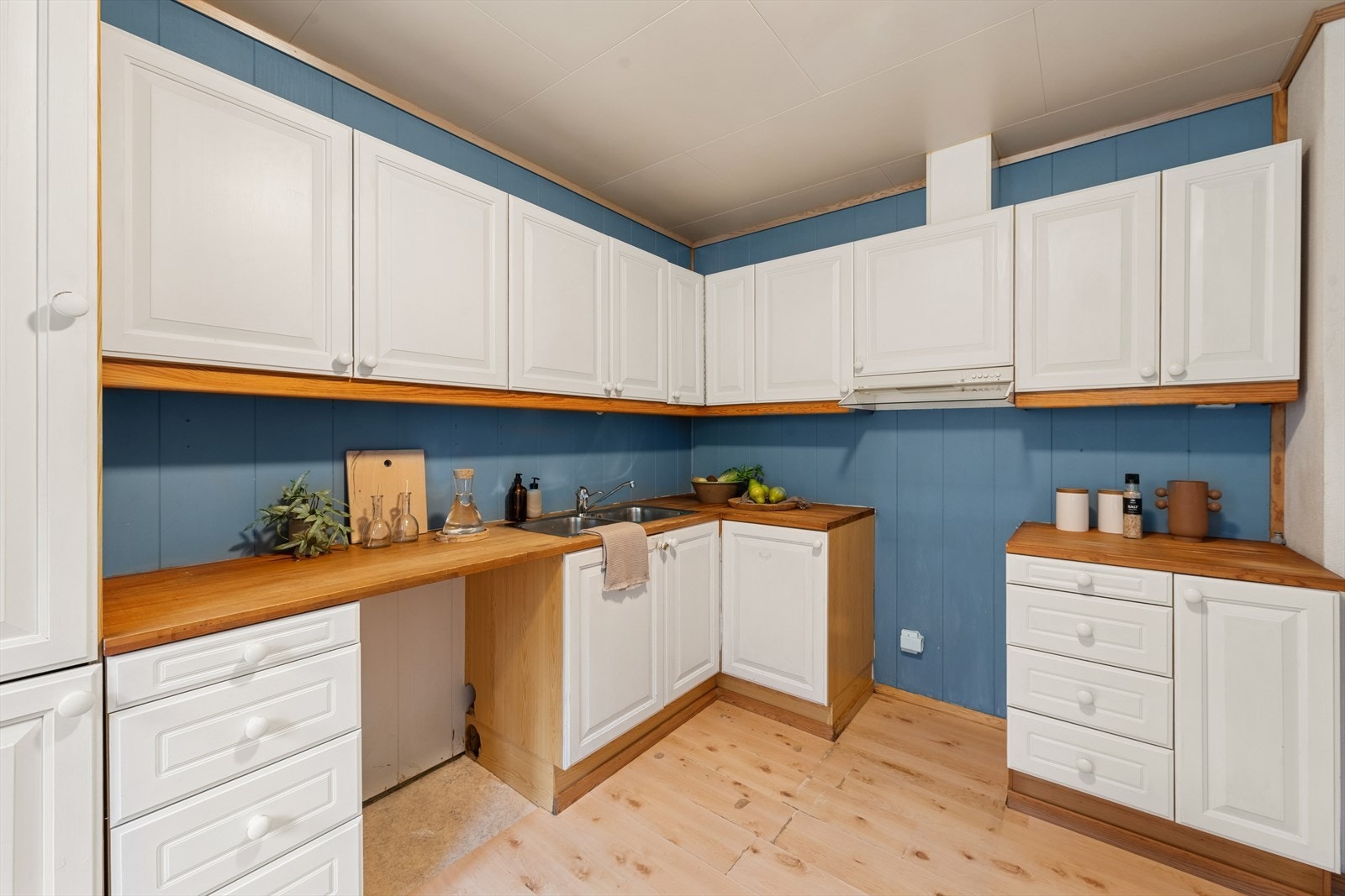 Kjøkkenet har en eldre innredning med profilerte, malte fronter og benkeplate i treverk. Galleribilde