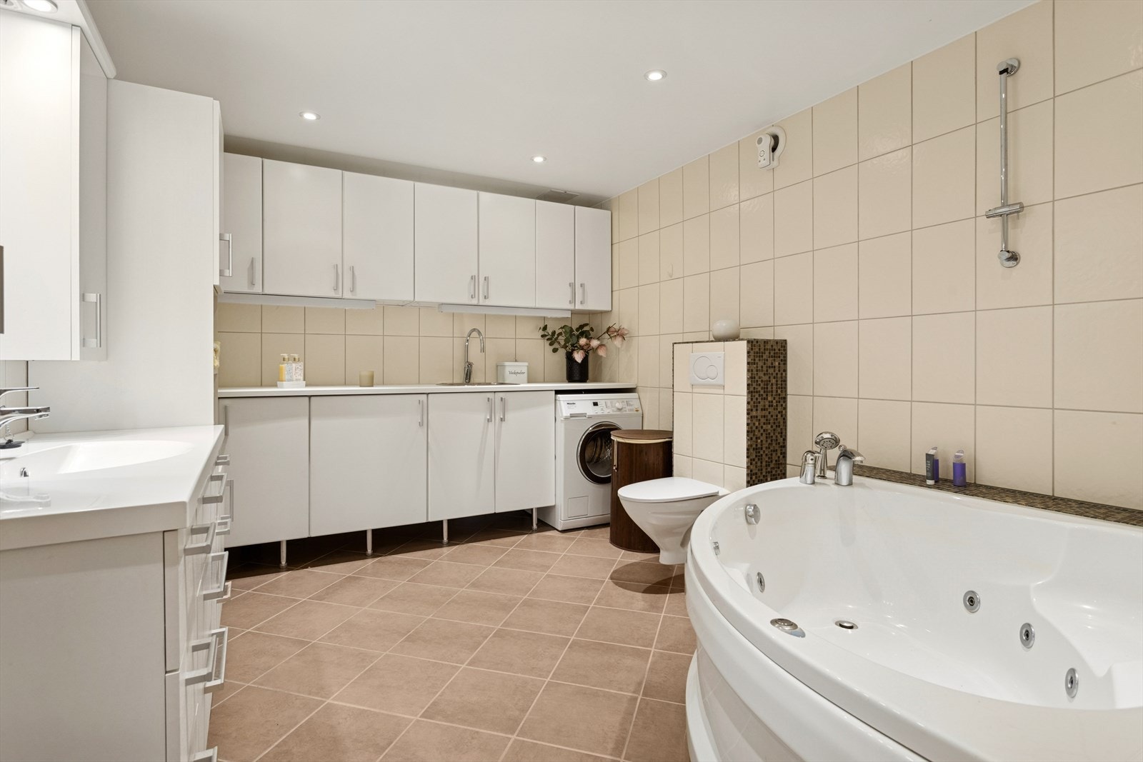 Pent flislagt bad fra 2011 på 11 kvm med veggmontert wc, hjørne boblekar, servant, uttak for vaskemaskin m.m. Galleribilde