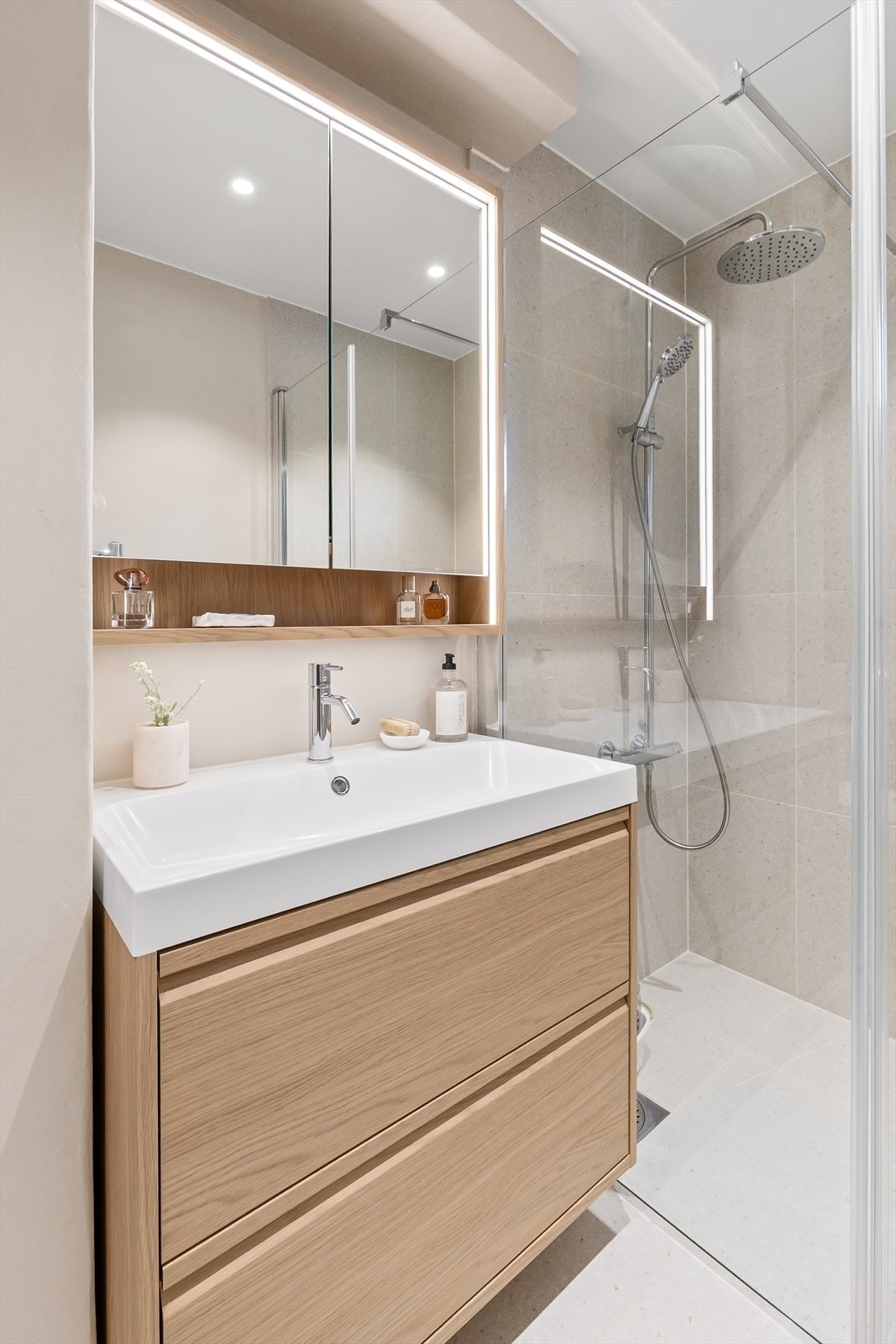 Her er det dusjhjørne med regndusj, vegghengt toalett og servantinnredning med speilskap. Galleribilde