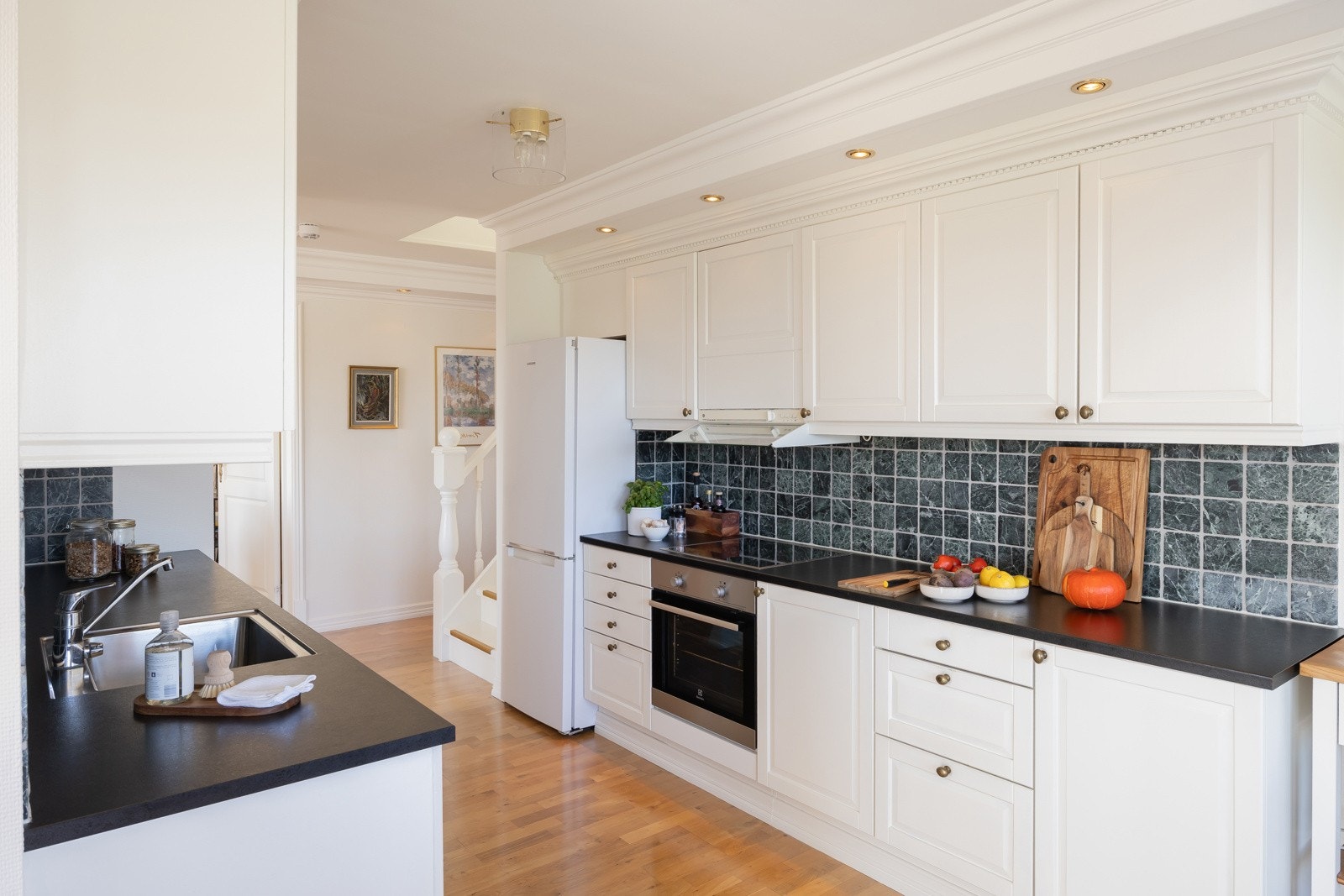 Kjøkkeninnredningen er hvitmalt heltrekjøkken i klassisk stil. Galleribilde