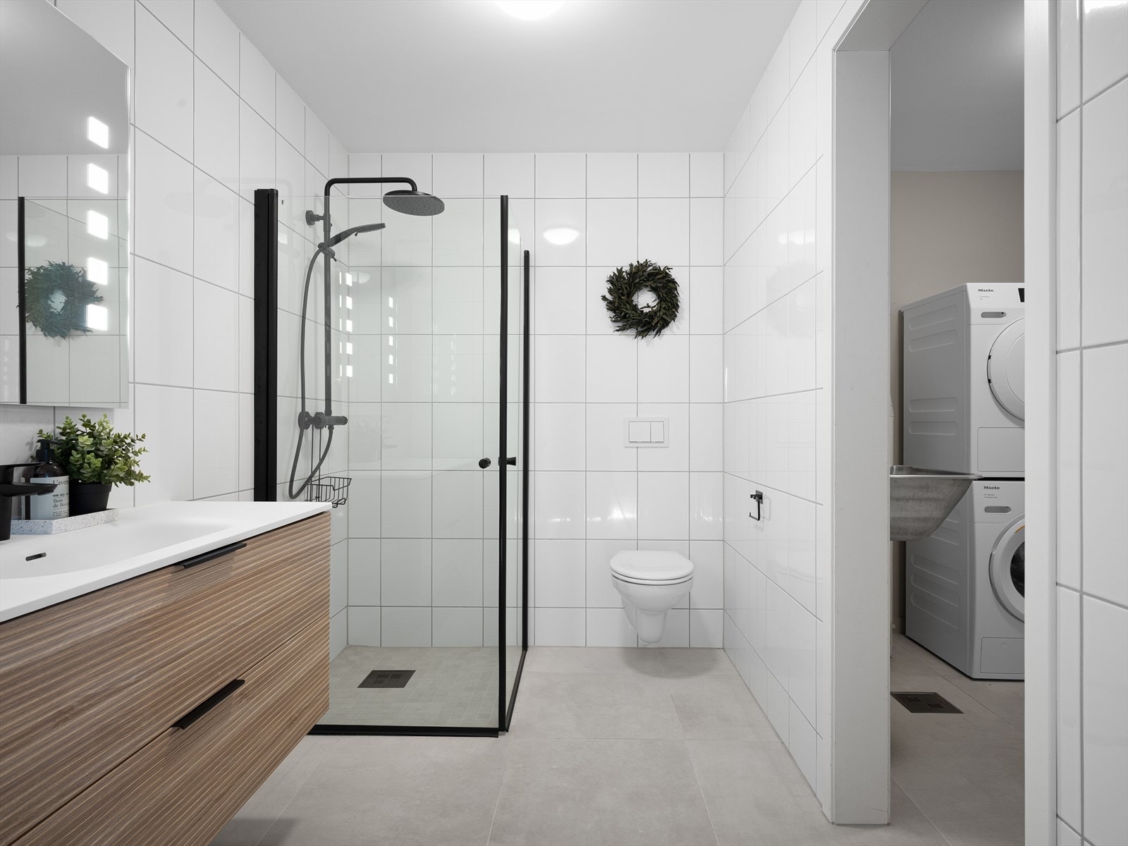 Badet er helfliset og har varme i gulvet for ekstra komfort. Moderne innredning og tidsriktige farger på fliser gir rommet et elegant preg Galleribilde