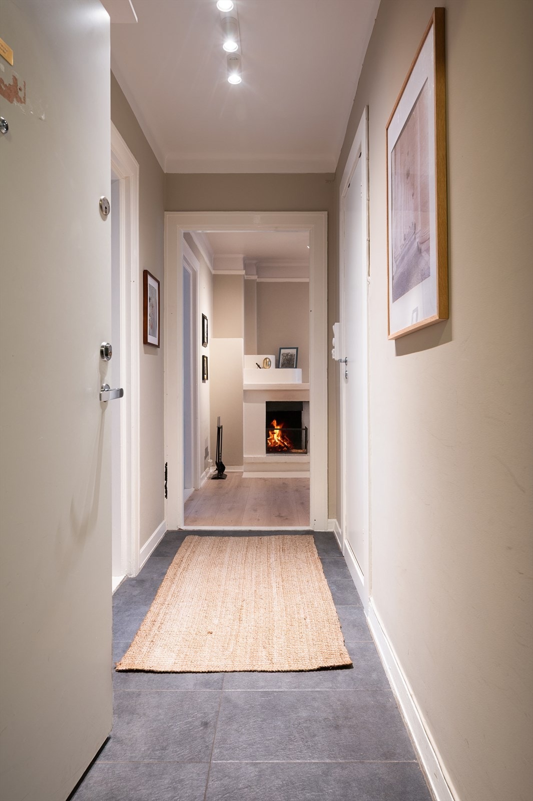 Fra inngangspartiet har man en innbydende siktlinje mot peisen i stuen. Galleribilde