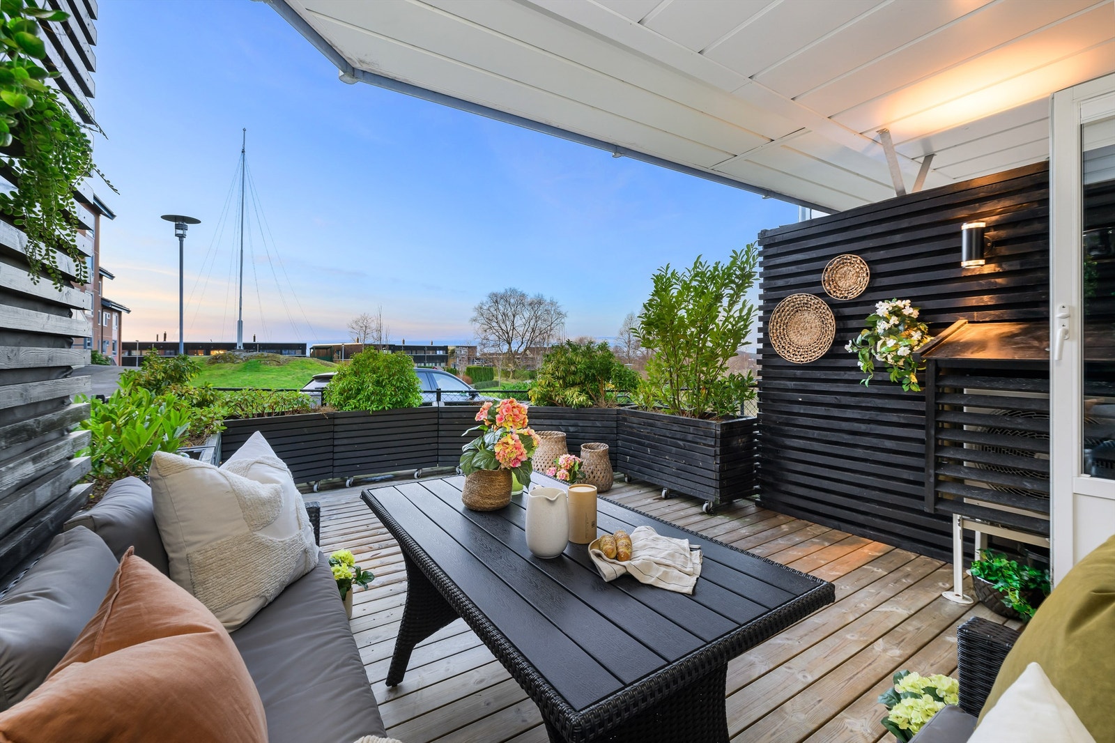 Terrassen er vestvendt og delvis overbygget med fine levegger og plantekasser Galleribilde