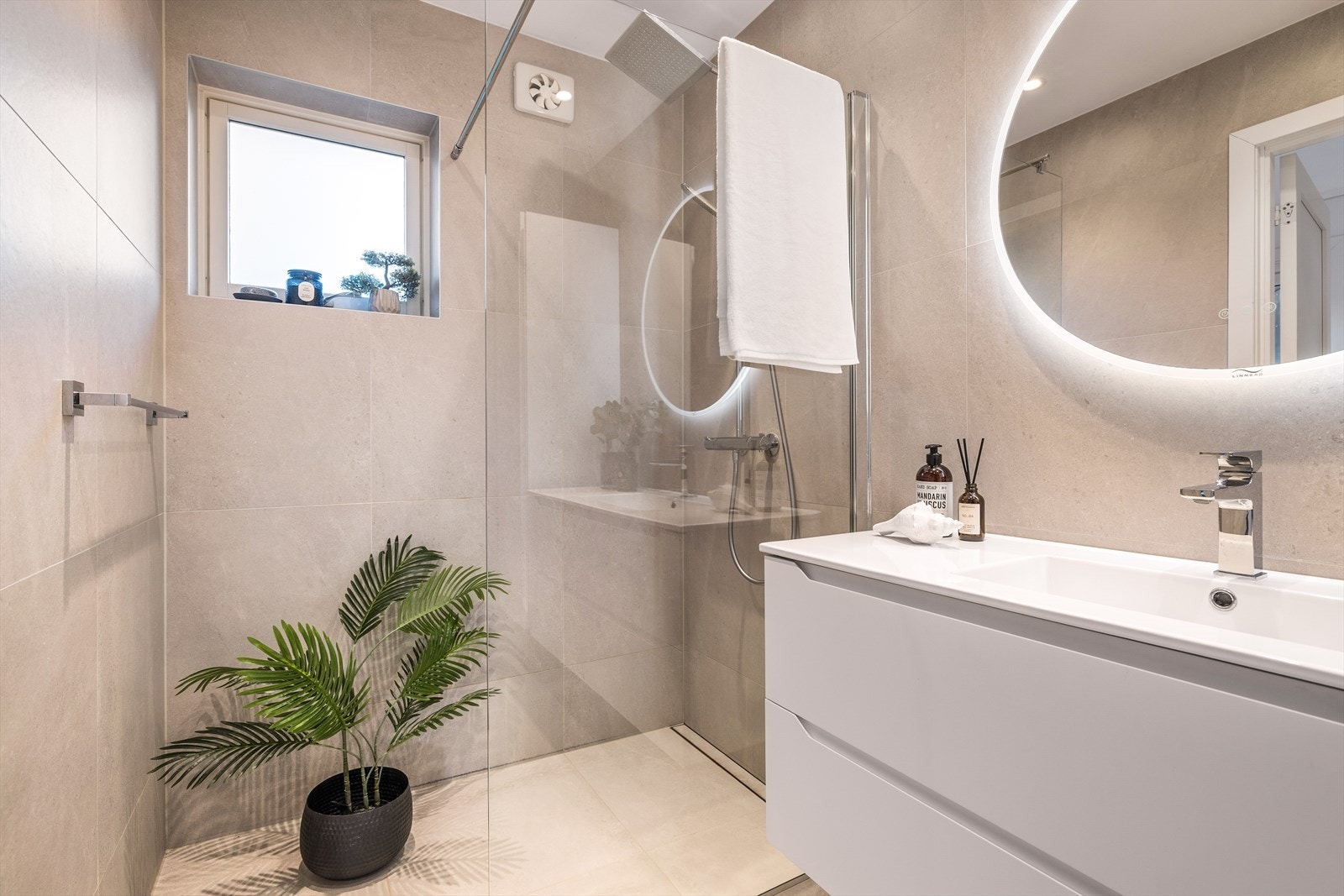 Helfliset med vegghengt toalett, helstøpt servant, skuffer med slette fronter, moderne dusjvegg i klart glass. Galleribilde