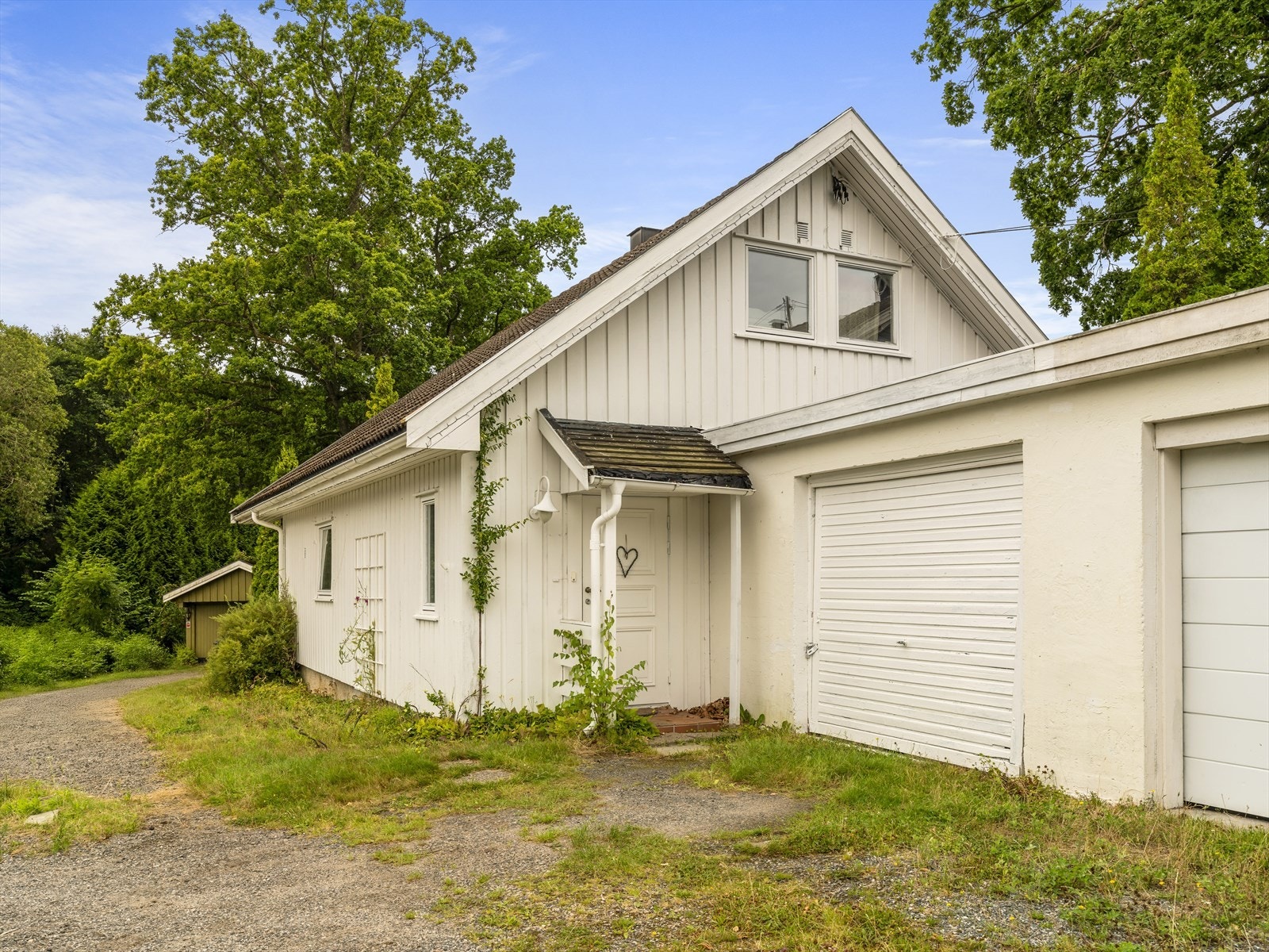 Hyggelig inngangsparti og en garasje tilhører boligens tomt. Flere biloppstillingsplasser på egen eiendom. Galleribilde