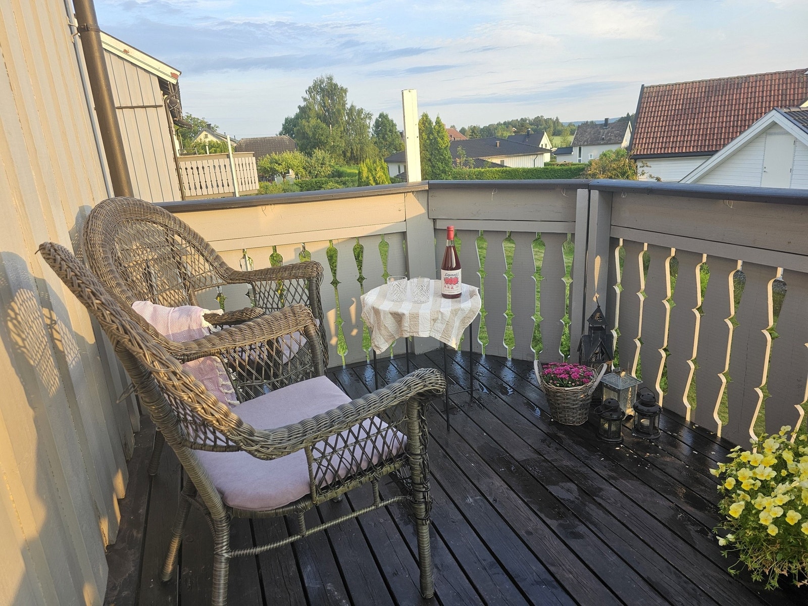 Balkong med kveldssol. Utsyn over boligområdet Moen med stille villahager. Galleribilde