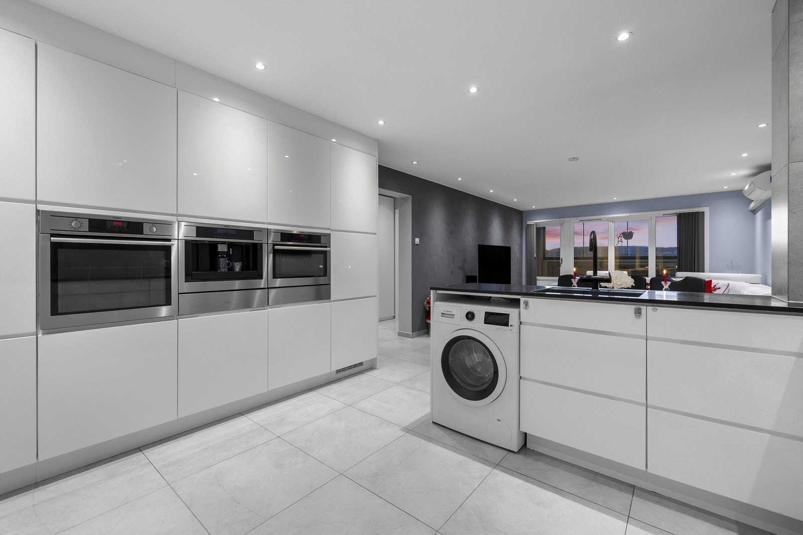 Moderne kjøkken med integrert kaffemaskin, komfyr og kombiovn. Galleribilde