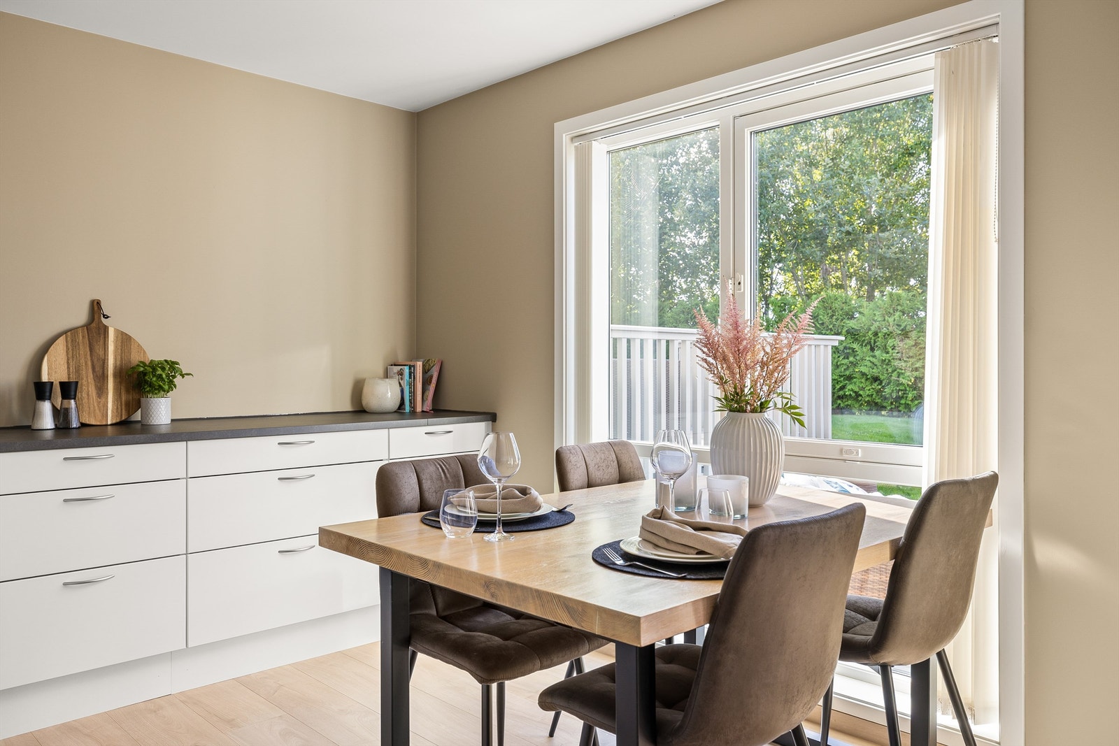 Spisebordet har sin plass foran kjøkkenets store vinduer som byr på utsyn til hagen. Galleribilde