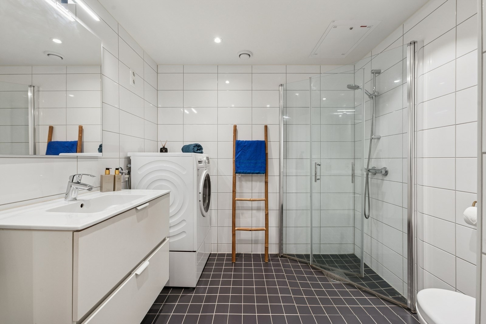 Badet er moderne med flislagte vegger og dusjhjørne med plassbesparende, innfellbare dusjvegger. Galleribilde