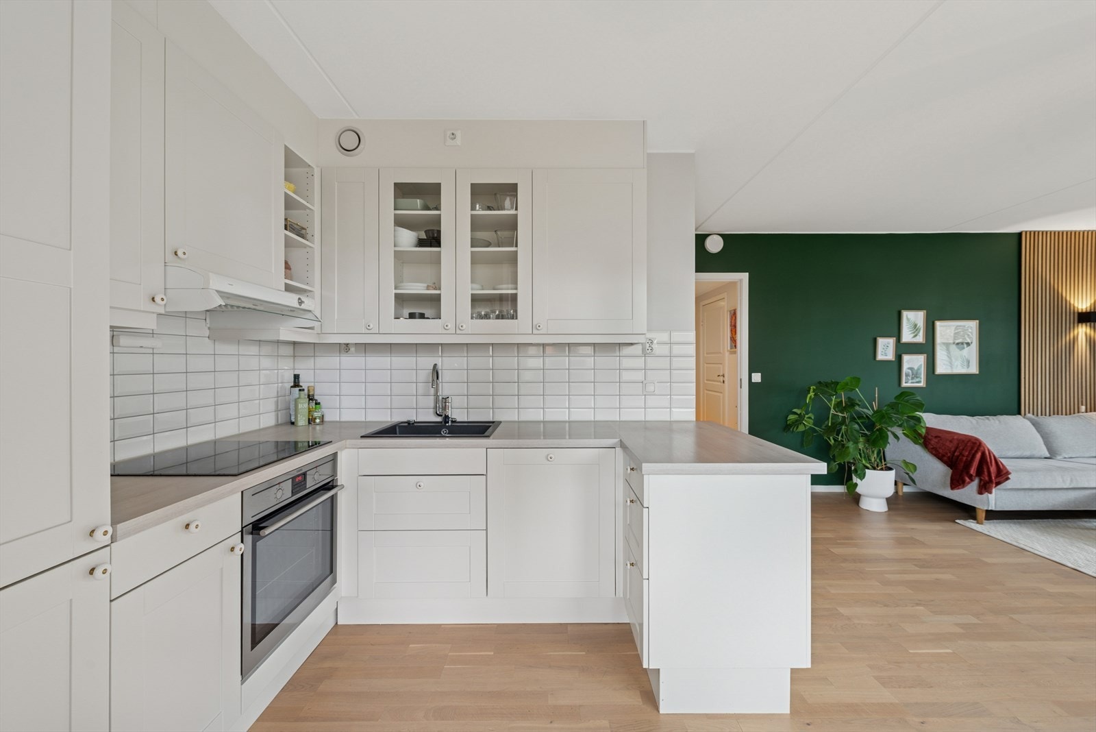 Kjøkkenet har hvite fronter, integrerte hvitevarer og god spiseplass i åpen planløsning. Galleribilde