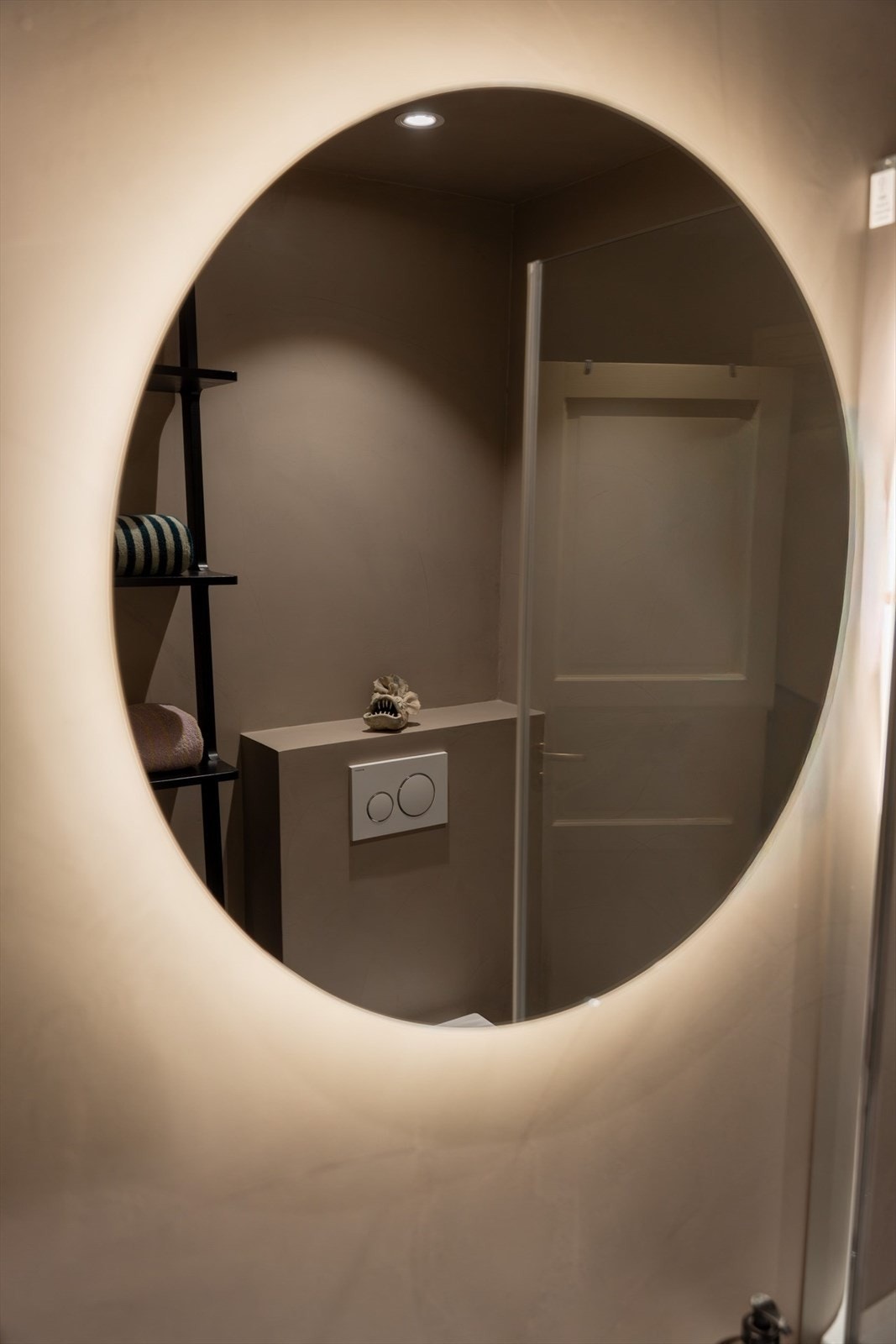 Innredningen inkluderer servant med underskap og speil, vegghengt toalett, skap, hjørnedusj samt opplegg for vaskemaskin. Galleribilde