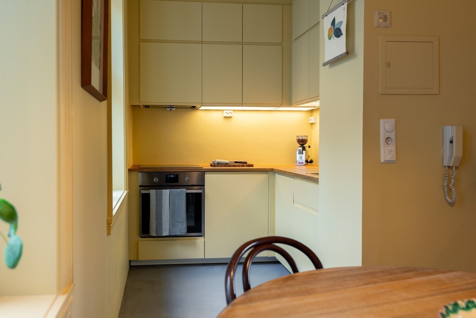 Innredningen er fra IKEA fra 2018 med glatte fronter og benkeplate i eik med nedfelt oppvaskkum. Overflatene på kjøkkenet er malt med gul farge, type mat Daybreak fra Pure and Original, likt resten av leiligheten. Galleribilde