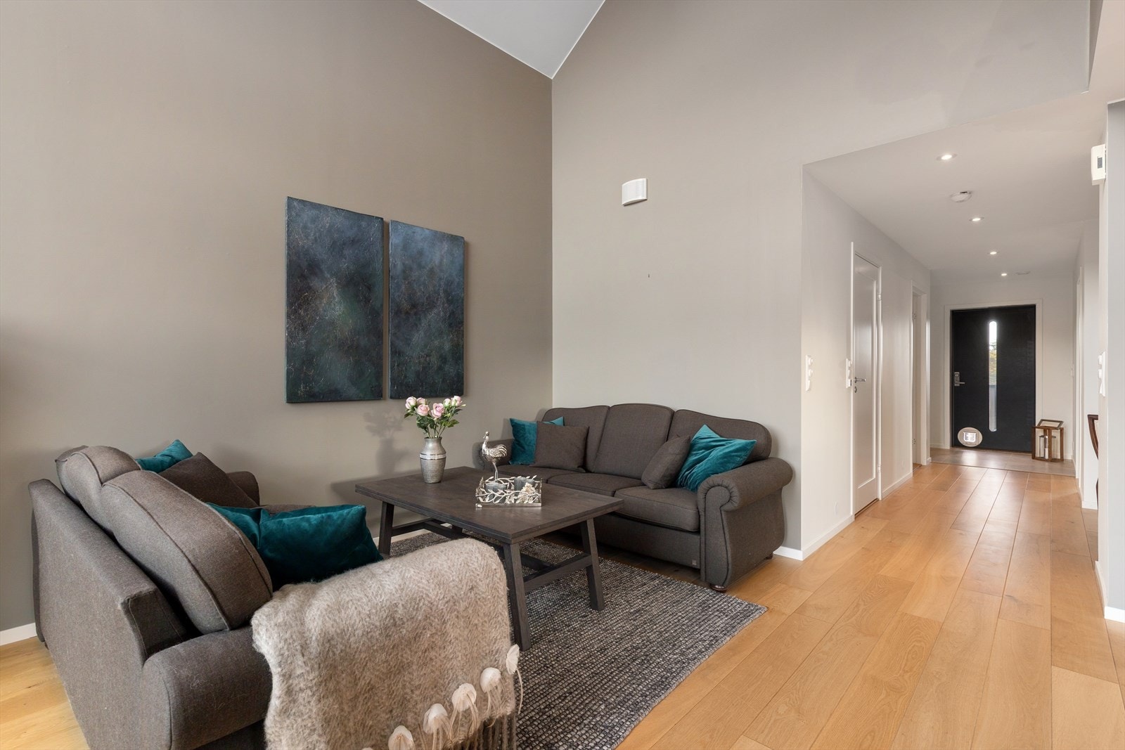 Rommet er preget av et varmt og elegant fargevalg, med listefrie løsninger som skaper en sømløs overgang mellom overflatene. Galleribilde