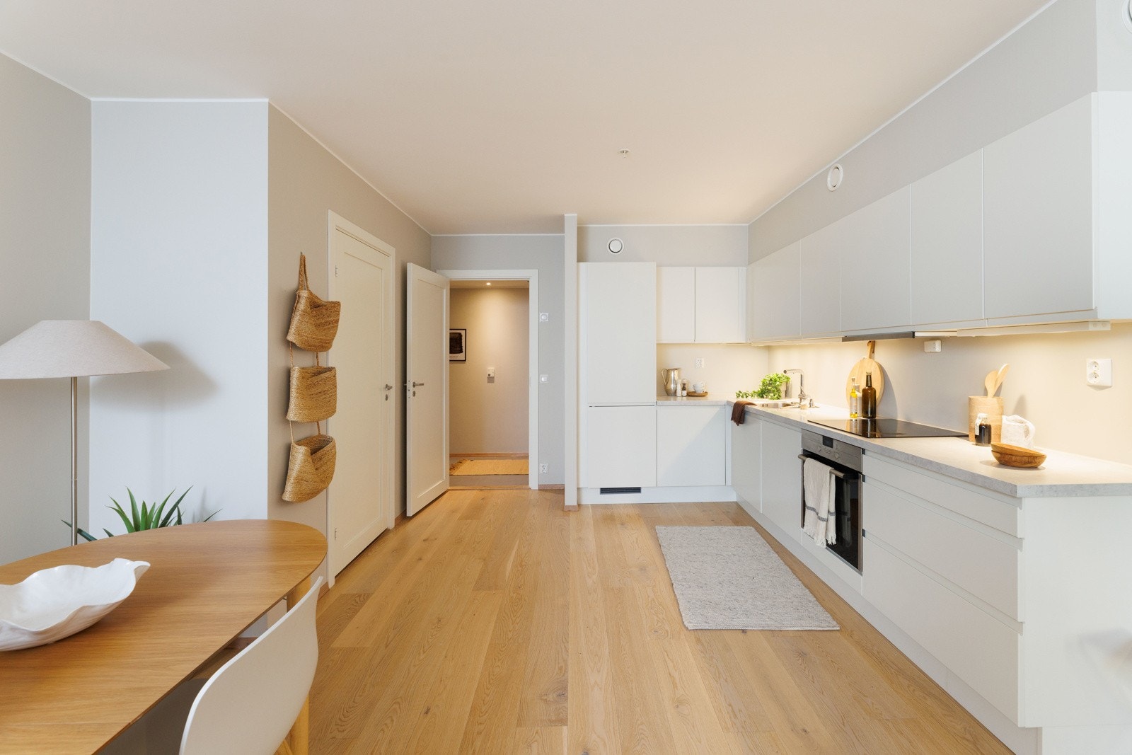 Kjøkkeninnredning fra Sigdal med integrerte hvitevarer fra Siemens og Bosch - hvite, glatte fronter og lys grå laminat benkeplate Galleribilde