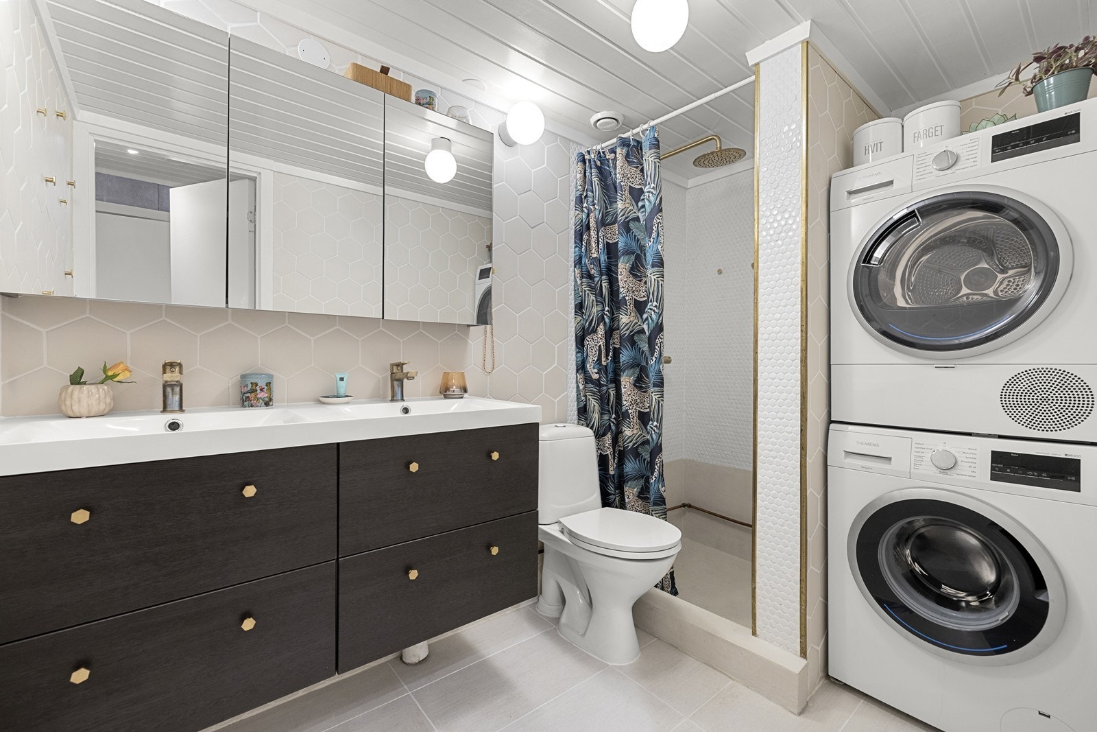 Badet ble oppgradert i 2021 og fremstår som moderne og funksjonelt. Rommet har fliser på gulv og vegger, med microsement i dusjsonen. Det er gulvvarme og integrerte downlights i taket. Galleribilde