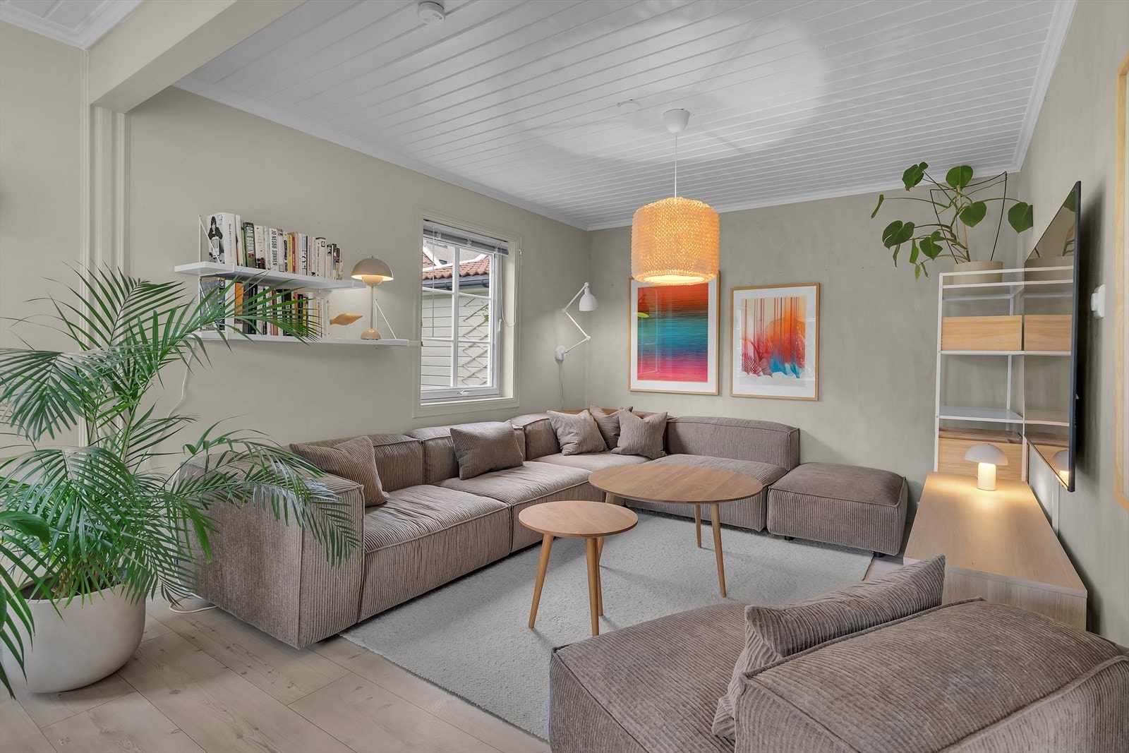 Lys og fin stue | Denne delen av stuen er opprinnelig et godkjent soverom, hvor veggen nå er fjernet for å få større stue. Dette kan enkelt tilbakeføres ved å sette opp lettvegg med dør. Det er derfor heller ikke varme i gulvet i denne delen av stuen. Galleribilde