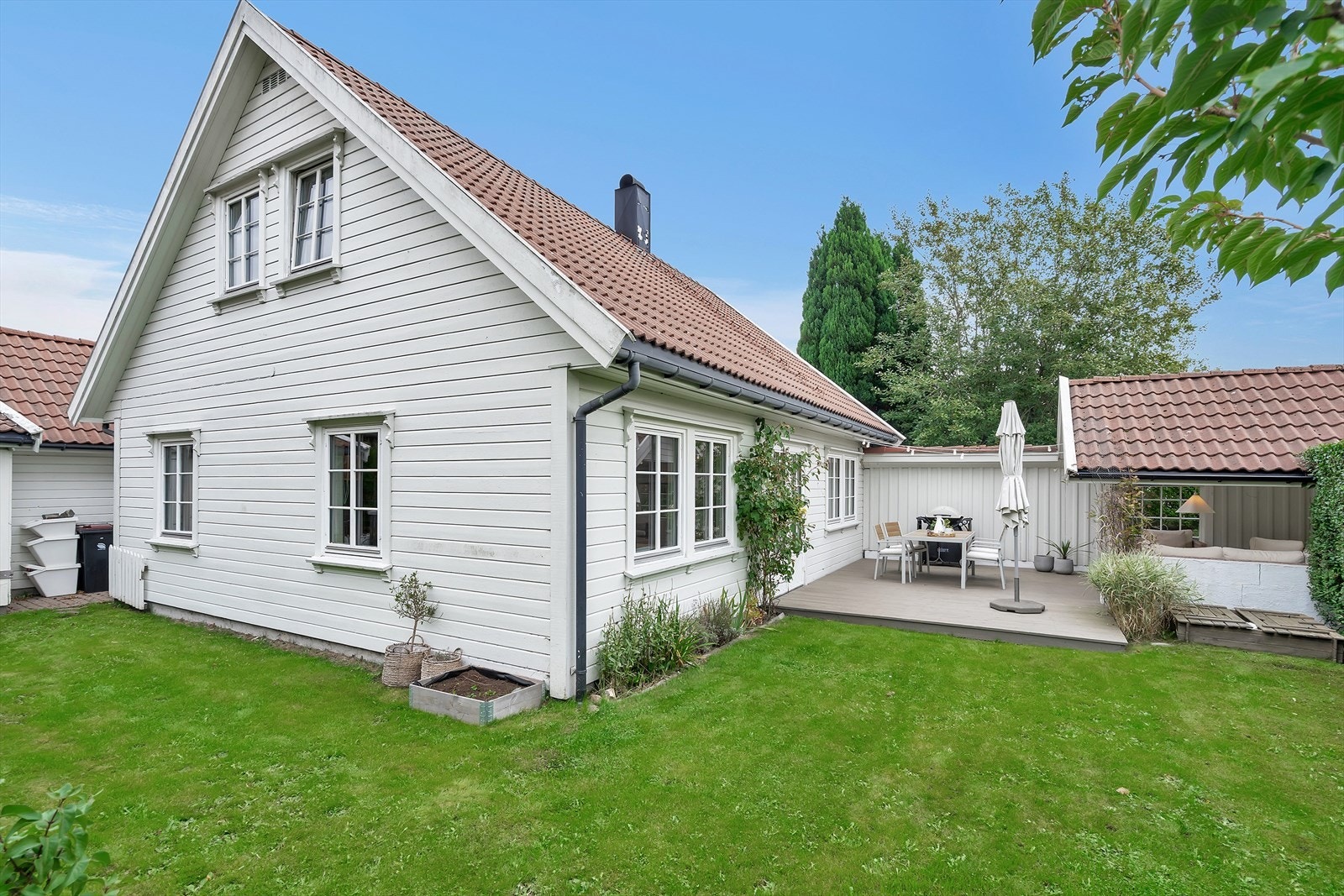 Fra stue/kjøkken kommer du ut på denne hyggelige terrassen | Det er også adkomst rundt boligen til gårdsplassen og til garasjen. Galleribilde