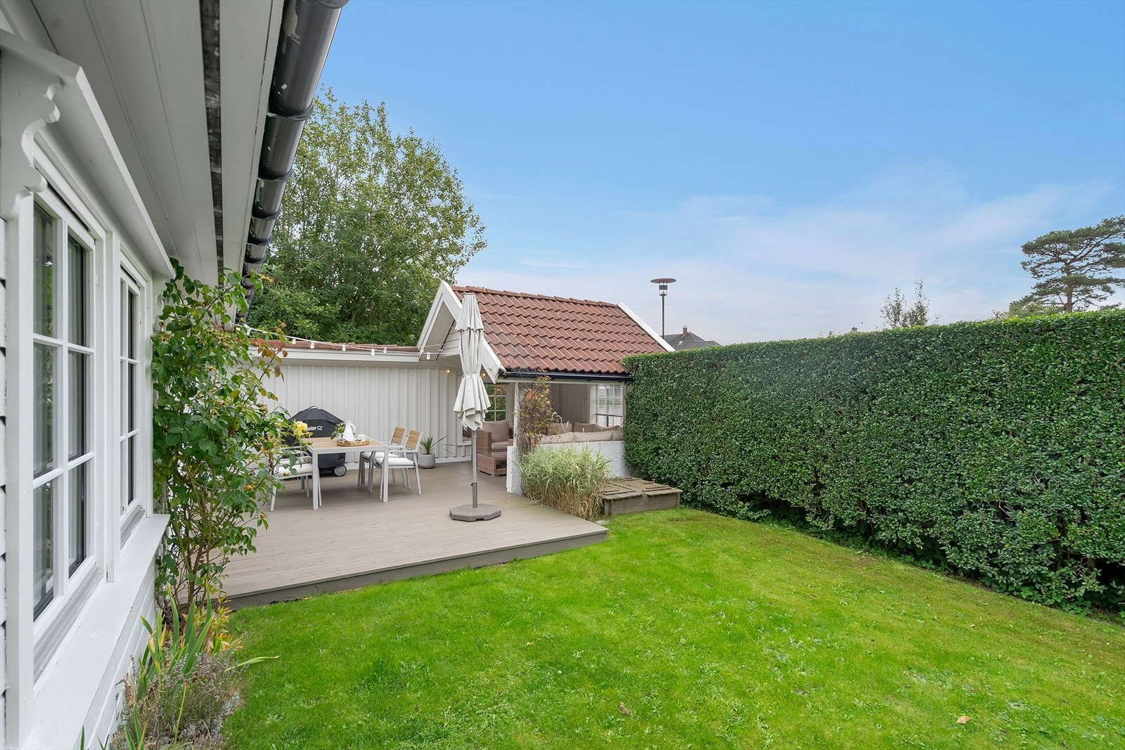 Sommergrønn hekk mot lekeplassen som er like ved. Galleribilde