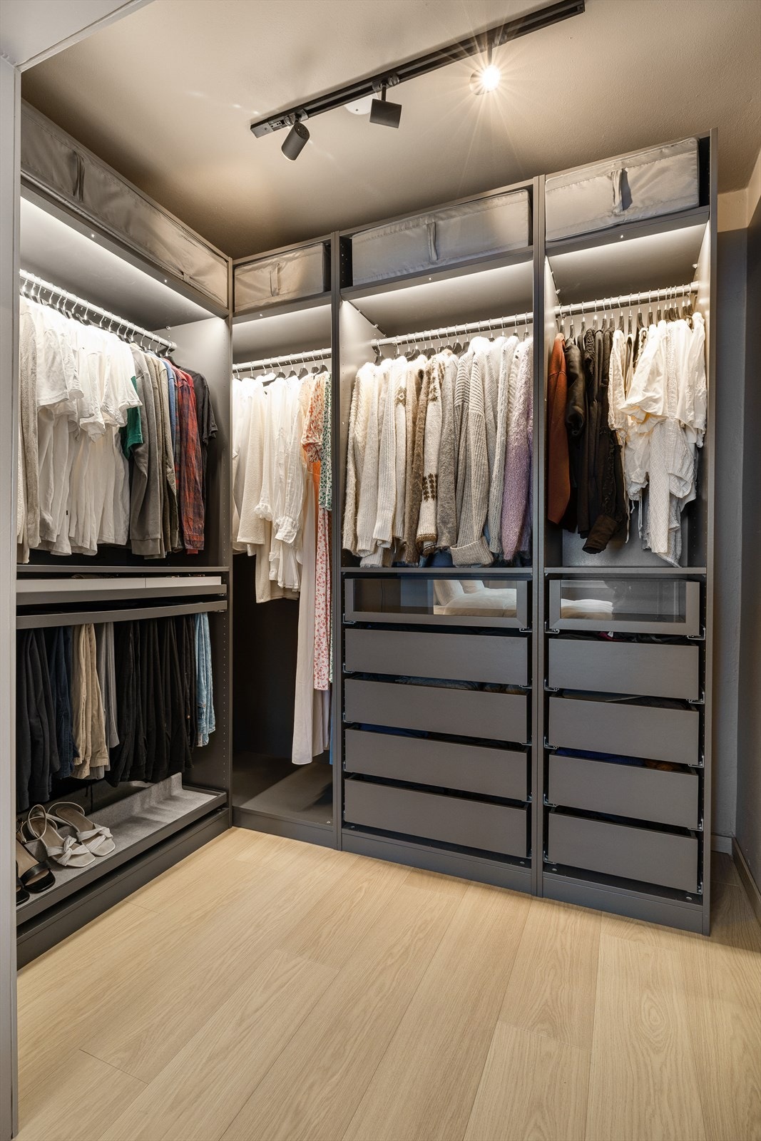 Lekkert garderoberom med svært praktisk innredning fra Ikea Pax med integrert belysning og spotskinne i tak. Innredningen har praktiske skuffer for oppbevaring og skottøy som kan trekkes ut Galleribilde